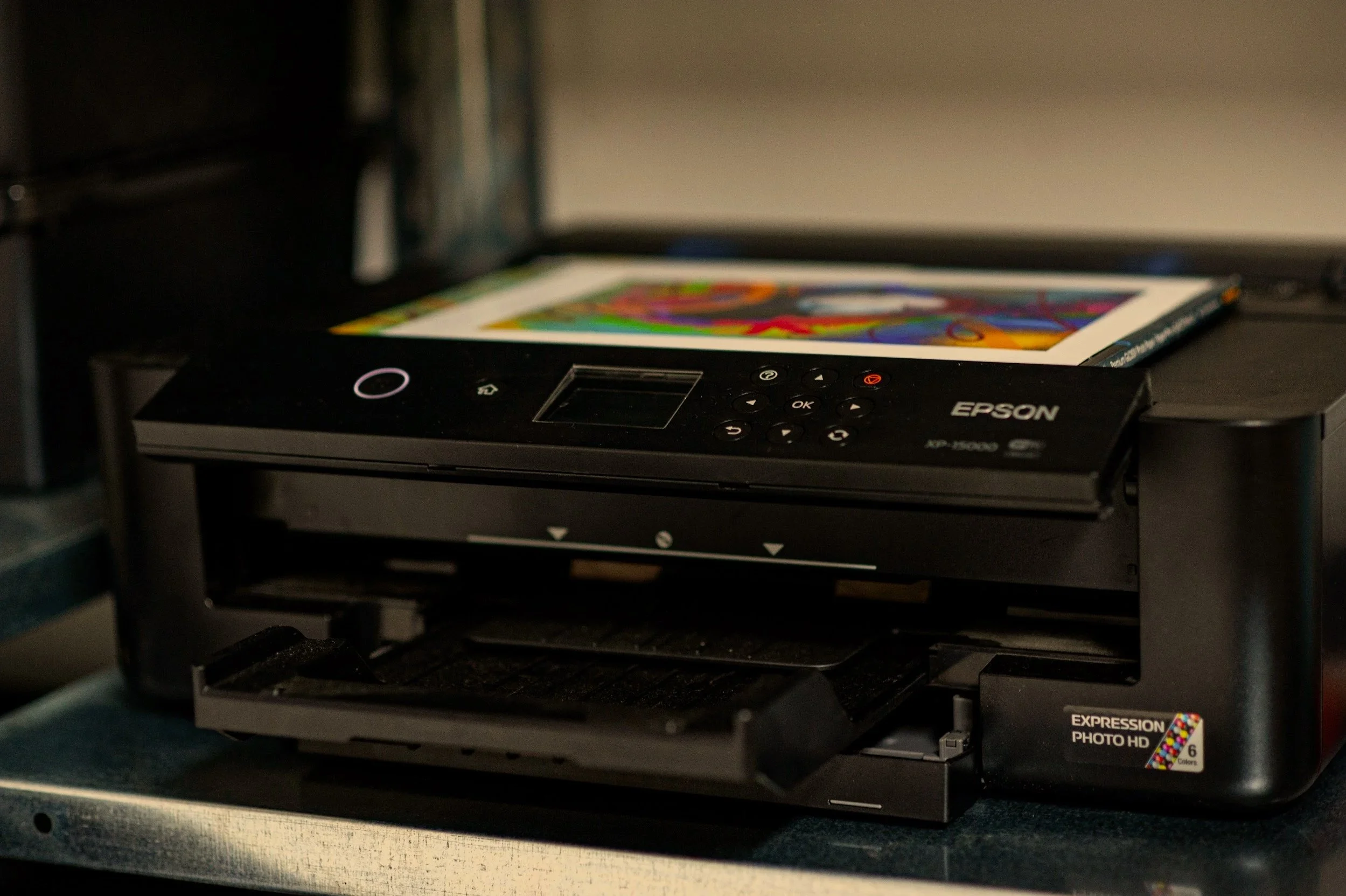 Epson photo printer on a wooden surface with a colorful printed photo resting on top