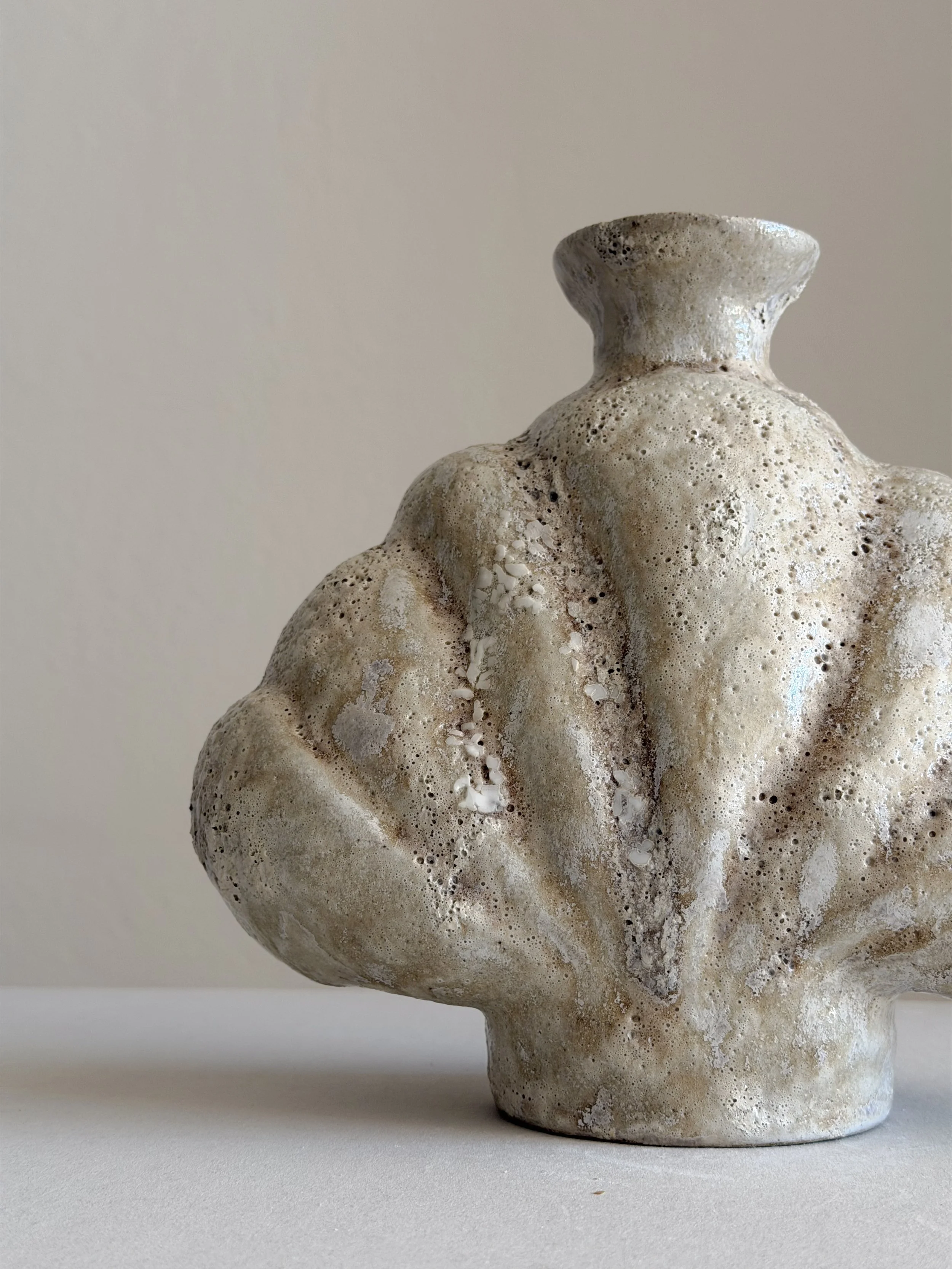 Shell in Beige: shaped like a deep-sea shell, full and protective, in soft beige stoneware, a sculptural ceramic vase by Anastasia Babenko