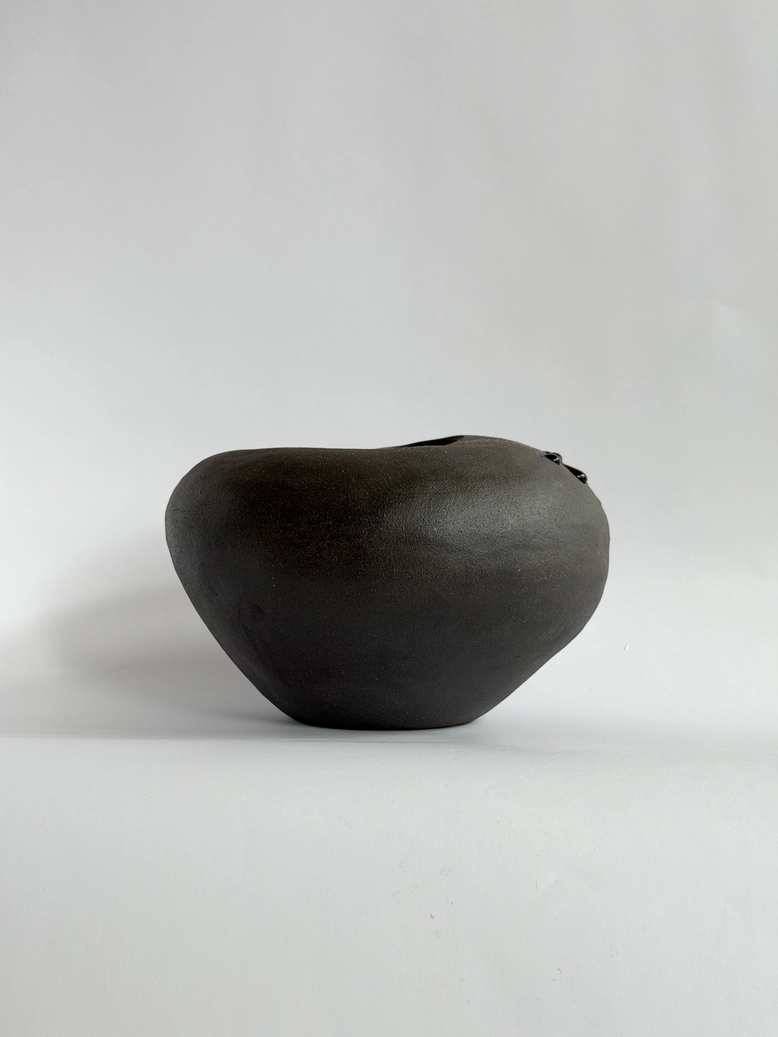 Whispering Stone, shaped like a smooth river stone, organic and calming — sculptural ceramic vase sculptural decor for design-led spaces