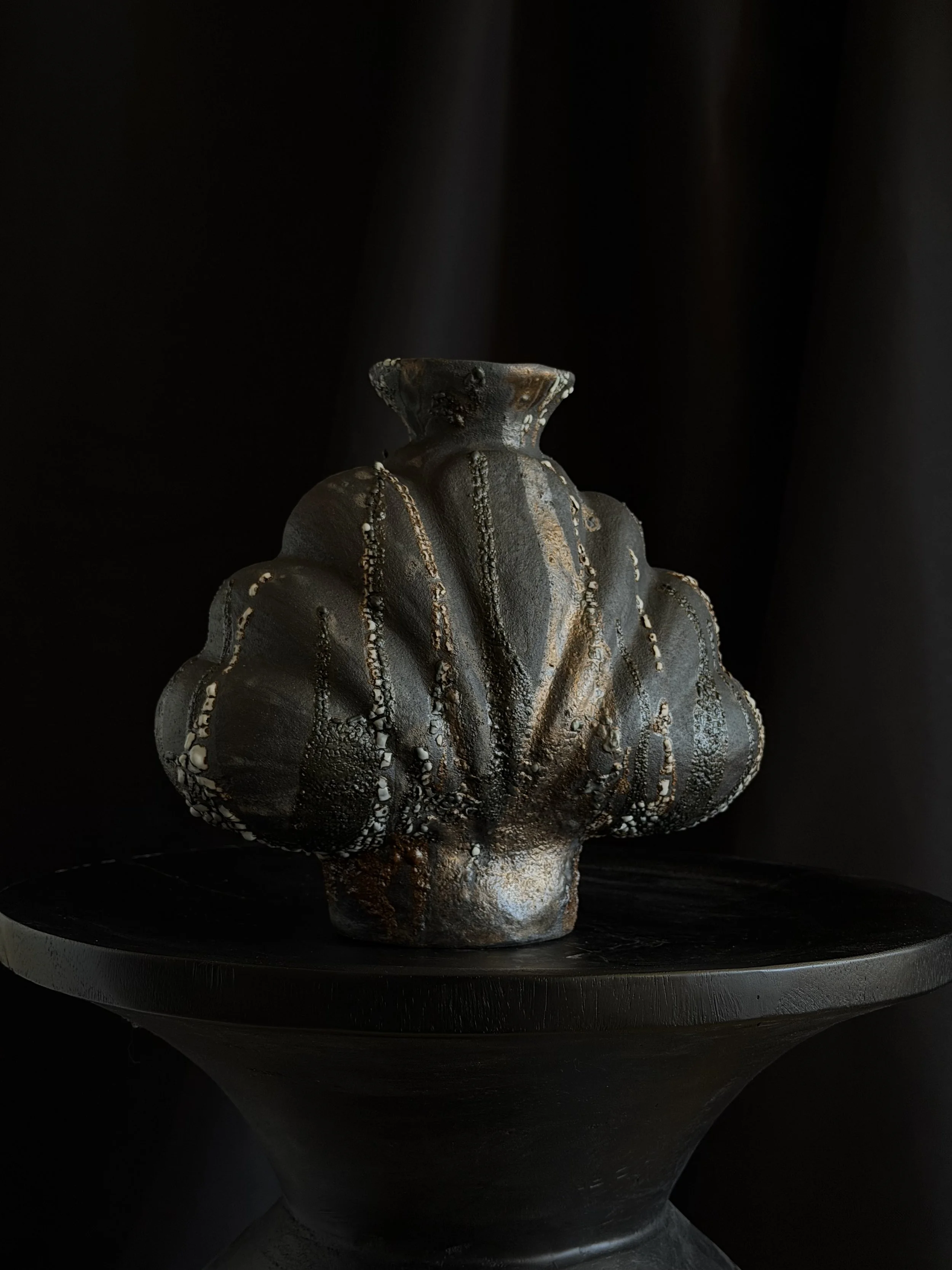 Shell in Black: with heavy scalloped ridges and a dark, stony matte finish, a sculptural ceramic vase by Anastasia Babenko
