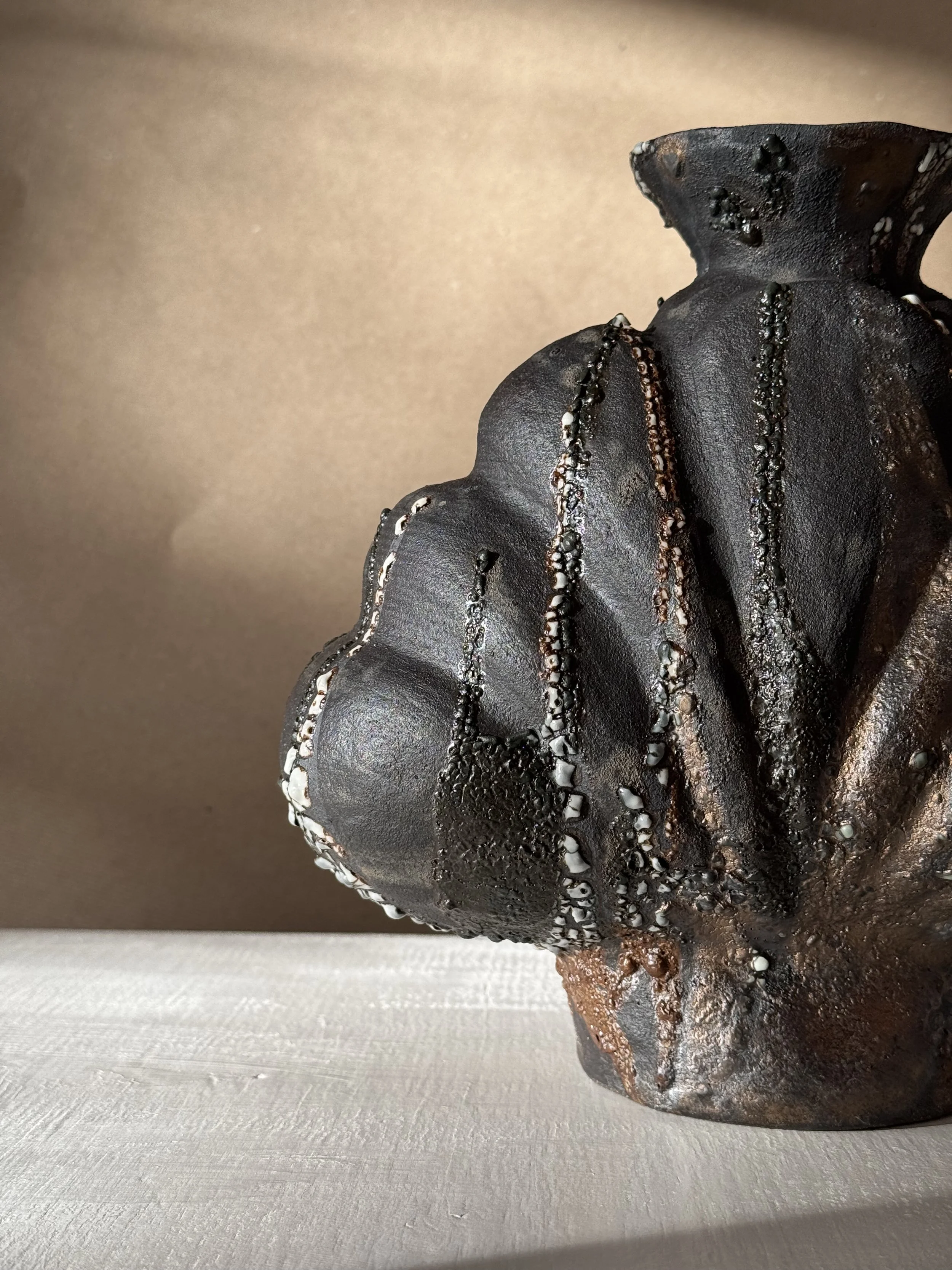 Shell in Black by Anastasia Babenko — with heavy scalloped ridges and a dark, stony matte finish, original ceramic art for interior designers