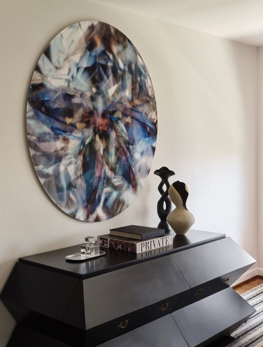 A hand-built cream stoneware vessel with a figure-like form, styled on a black console in a room designed by Holly A. Kopman Interior Design