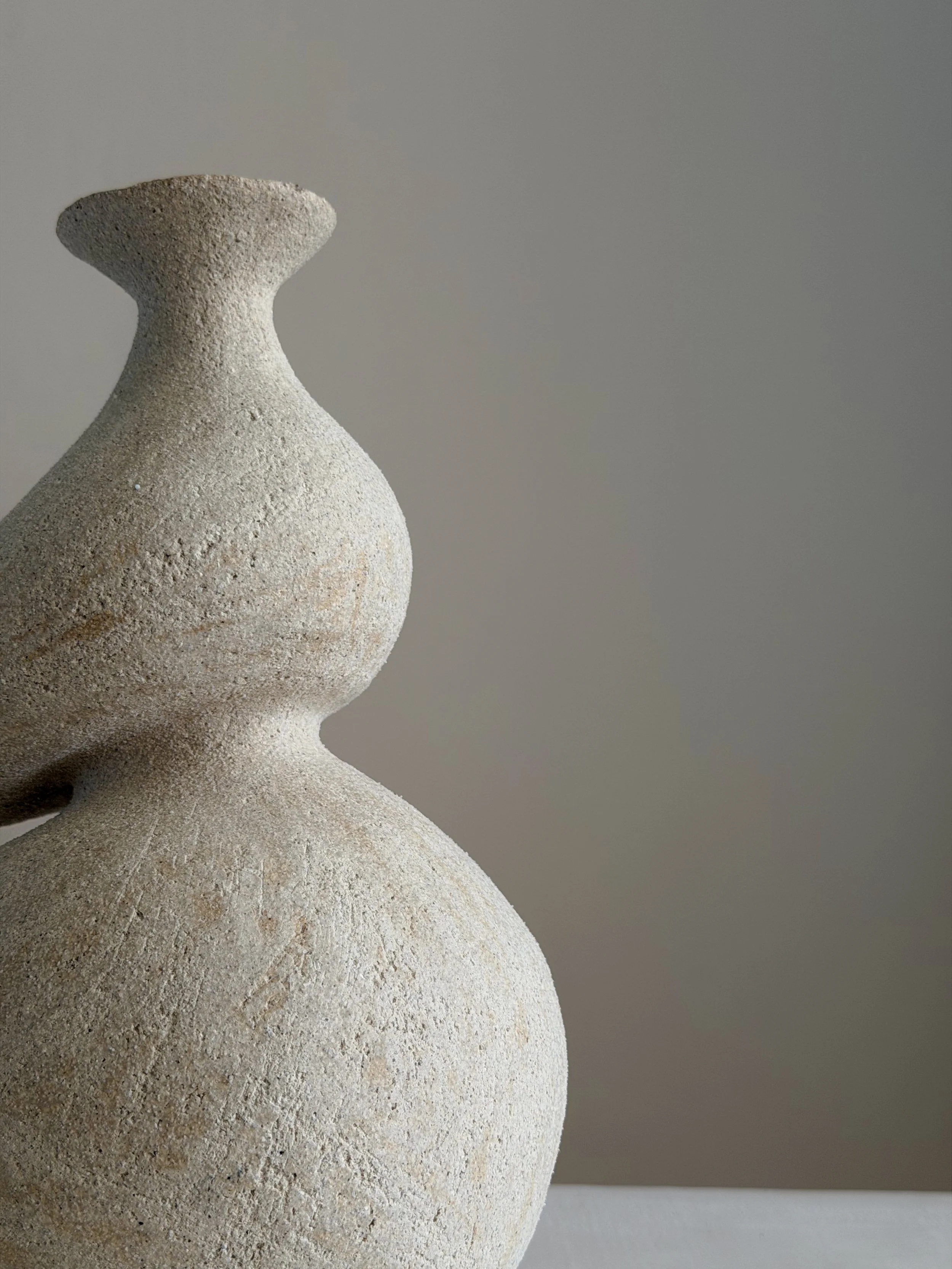 She 5, in the form of a woman caught mid-turn, tilting toward a slender neck — sculptural ceramic vase sculptural decor for design-led spaces
