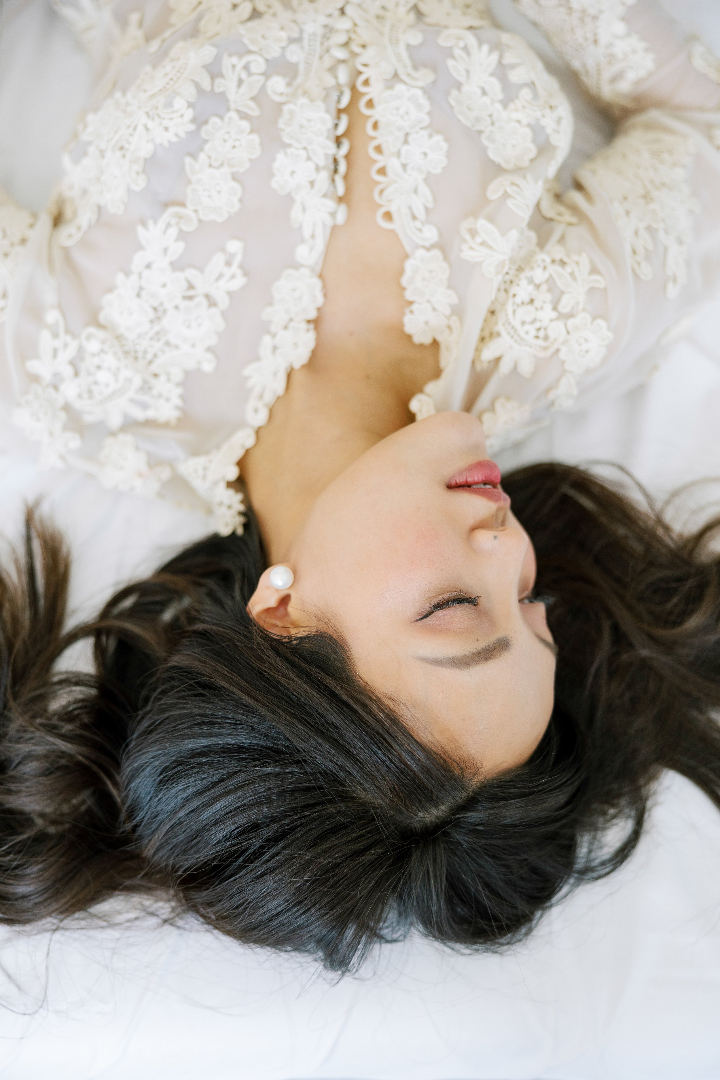 Woman laying down wearing a lace robe