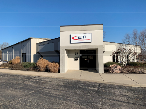 ETI company building with white facade, located at 75, on a cloudy day.