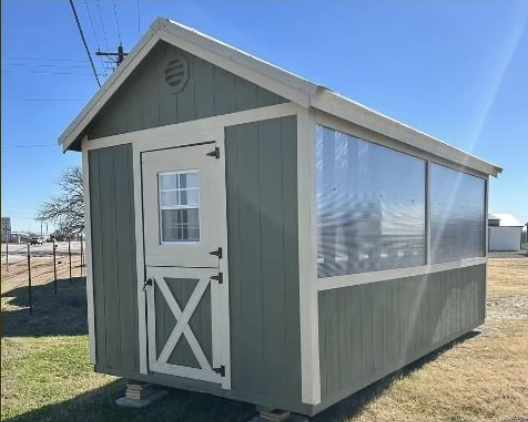 image of a green side view of a greenhouse on a lot.