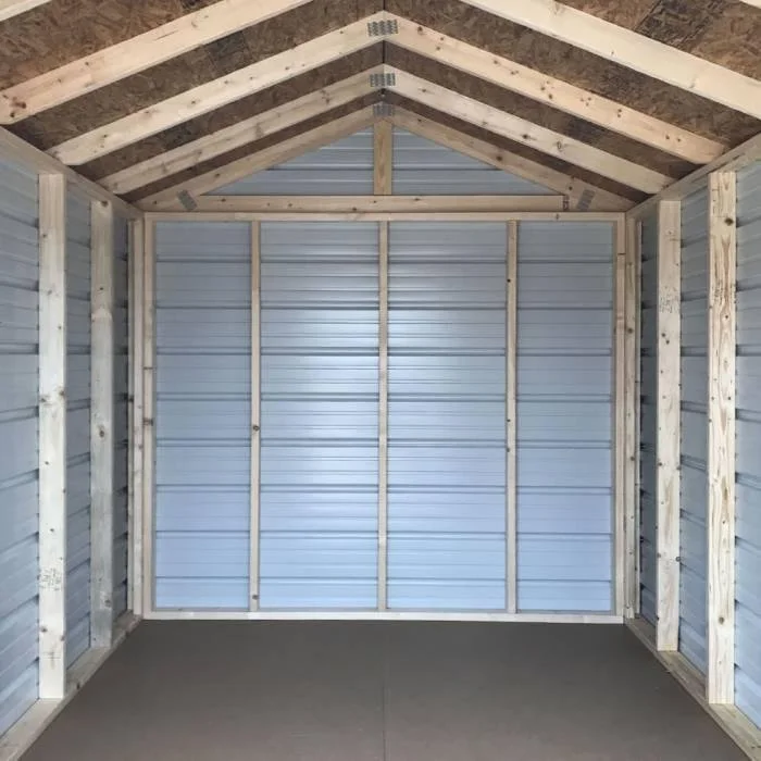 Interior of a small, unfinished metal storage shed with wooden framing and a sloped roof.
