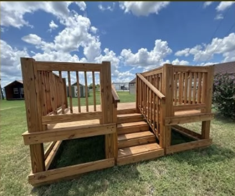 large wooden deck on a plot of green grass