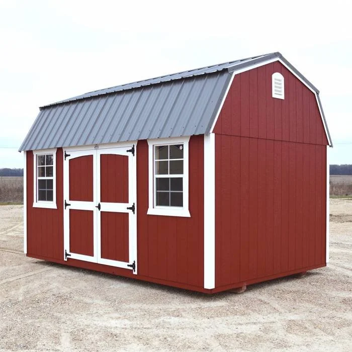 Red wooden shed with white trim, black hinges, double doors, two small windows, and a metal roof, situated outdoors on a dirt area.