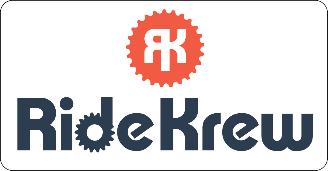 Logo for RideKrew featuring a gear icon in red with a stylized letter 'R' and the text 'RideKrew' in dark blue with gear motifs incorporated into the lettering.