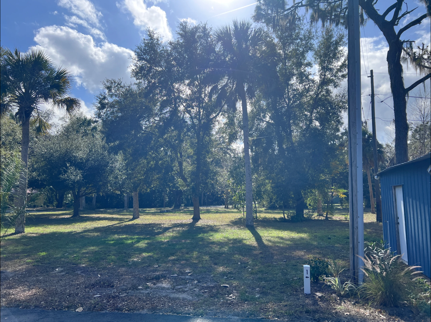 Sundown Republic camp site 1. Grass with shade trees and next to the garage.