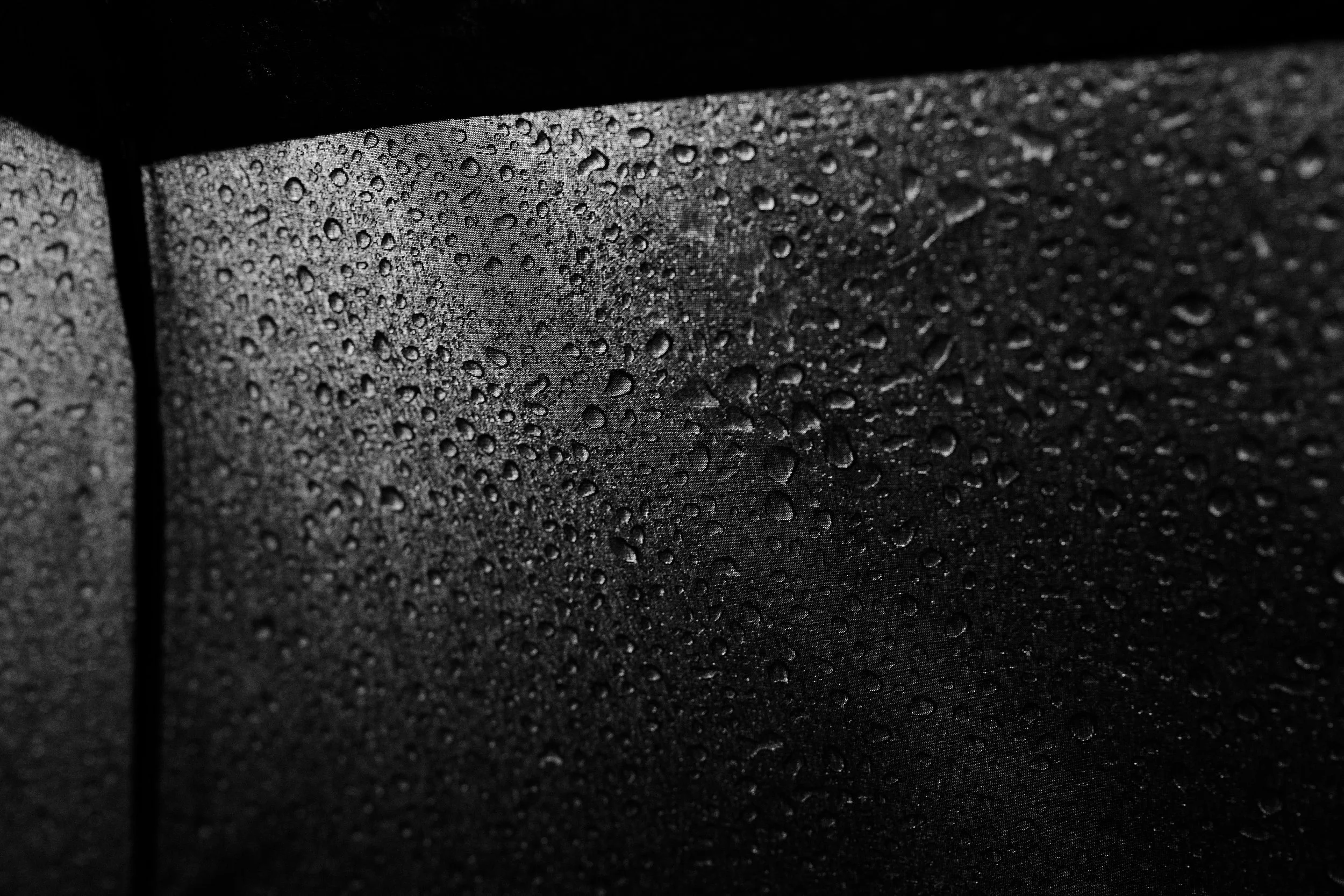Close-up of a waterproof surface with water droplets on it.