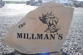 A large rock with a logo featuring a moose and the text 'The Millman's' engraved on it.