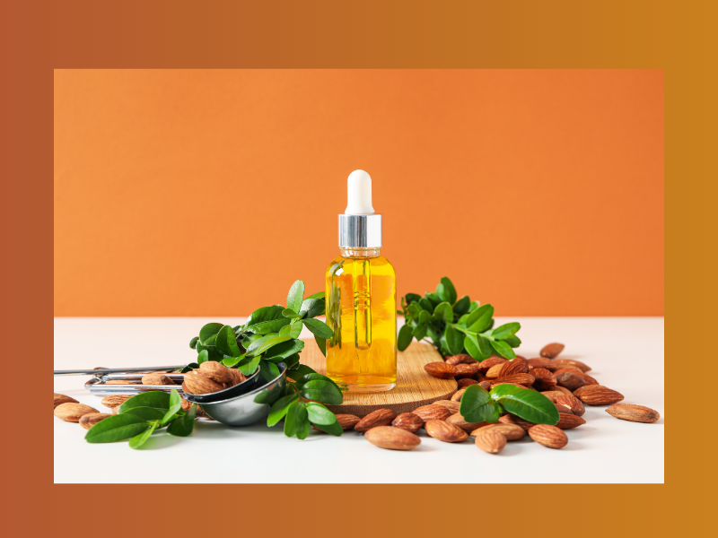 Sweet Almond Oil in a dropper bottle with almonds and greens.