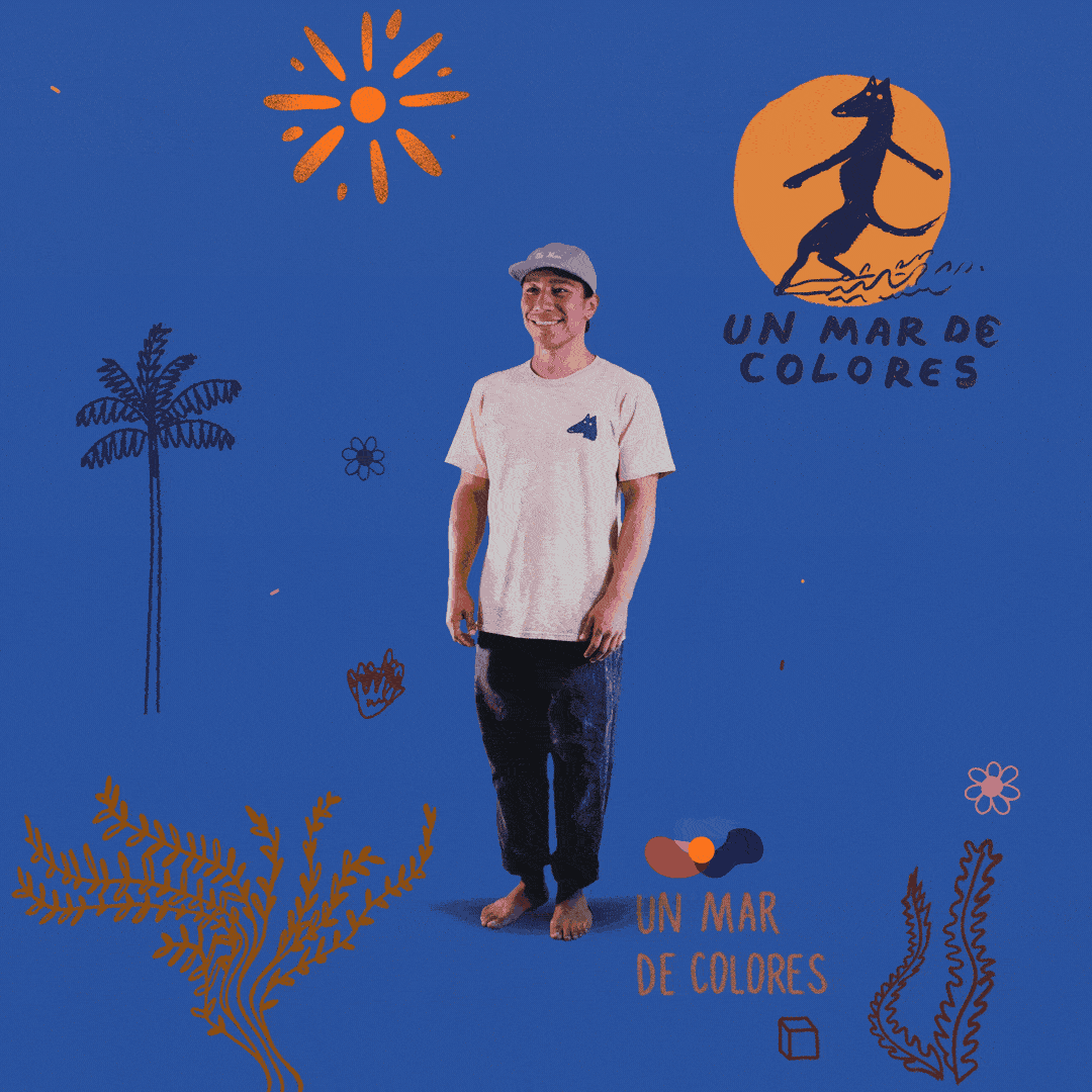 A young man standing barefoot against a blue background decorated with black-and-orange drawings of a sun, palm tree, seaweed, a small flower, and doodles, with the phrase 'Un Mar de Colores' written twice, once near a black dog silhouette on an orange circle and once near a black and orange abstract shape.