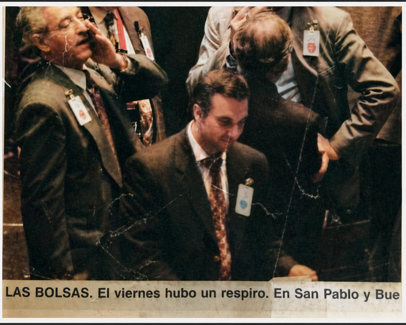 Varios hombres en trajes oscuros con identificaciones, algunos parecen descansar o estar cansados en un entorno cerrado.