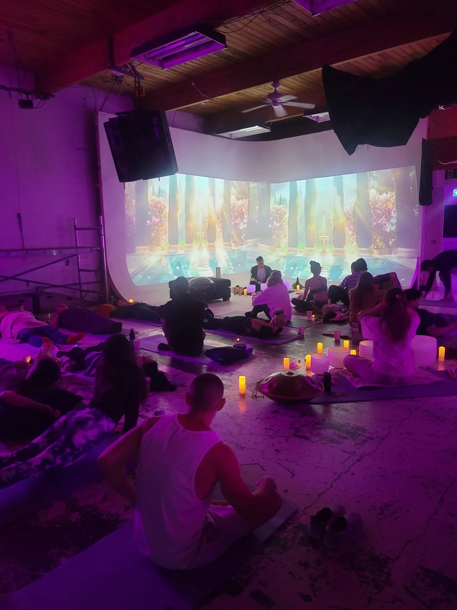A Solar Soul Circle sound bath where the guests are sitting up listening to Alex Ma guide them into the beginning of a meditation preparing to allow the frequency of sound to wash over them.