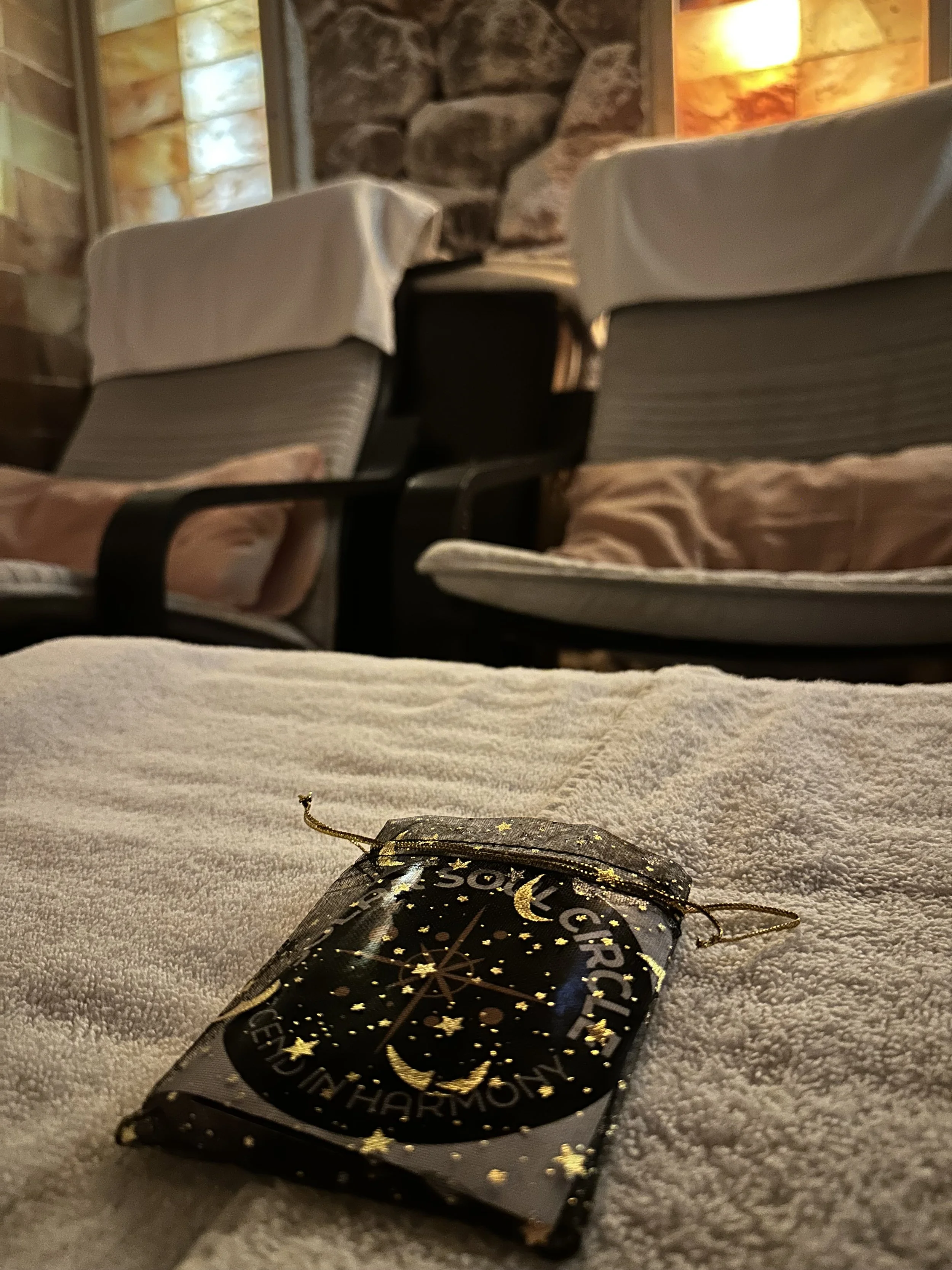 A close up of a Solar Soul Circle gift bag sitting on the foot rest of chairs within the Saltwonder Himalayan Salt Cave during a sound bath in North Vancouver