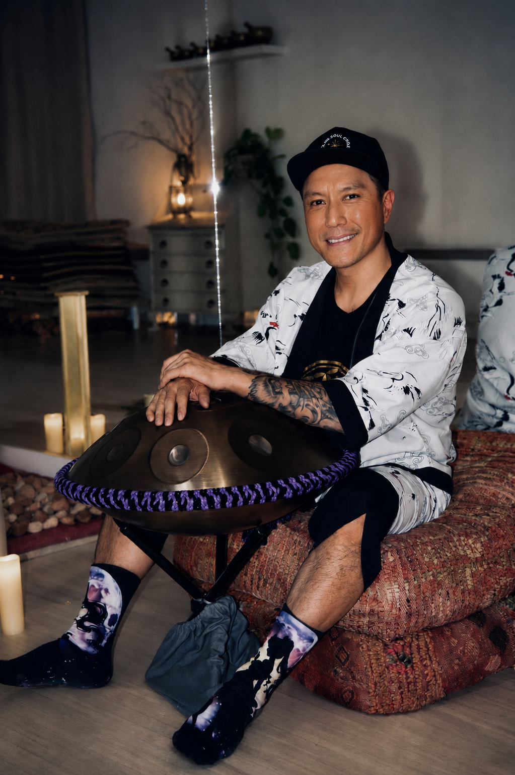 Alex Ma from Solar Soul Circle sitting with his handpan with a smile at a sound bath within Love & Peace Studio in Kitsilano