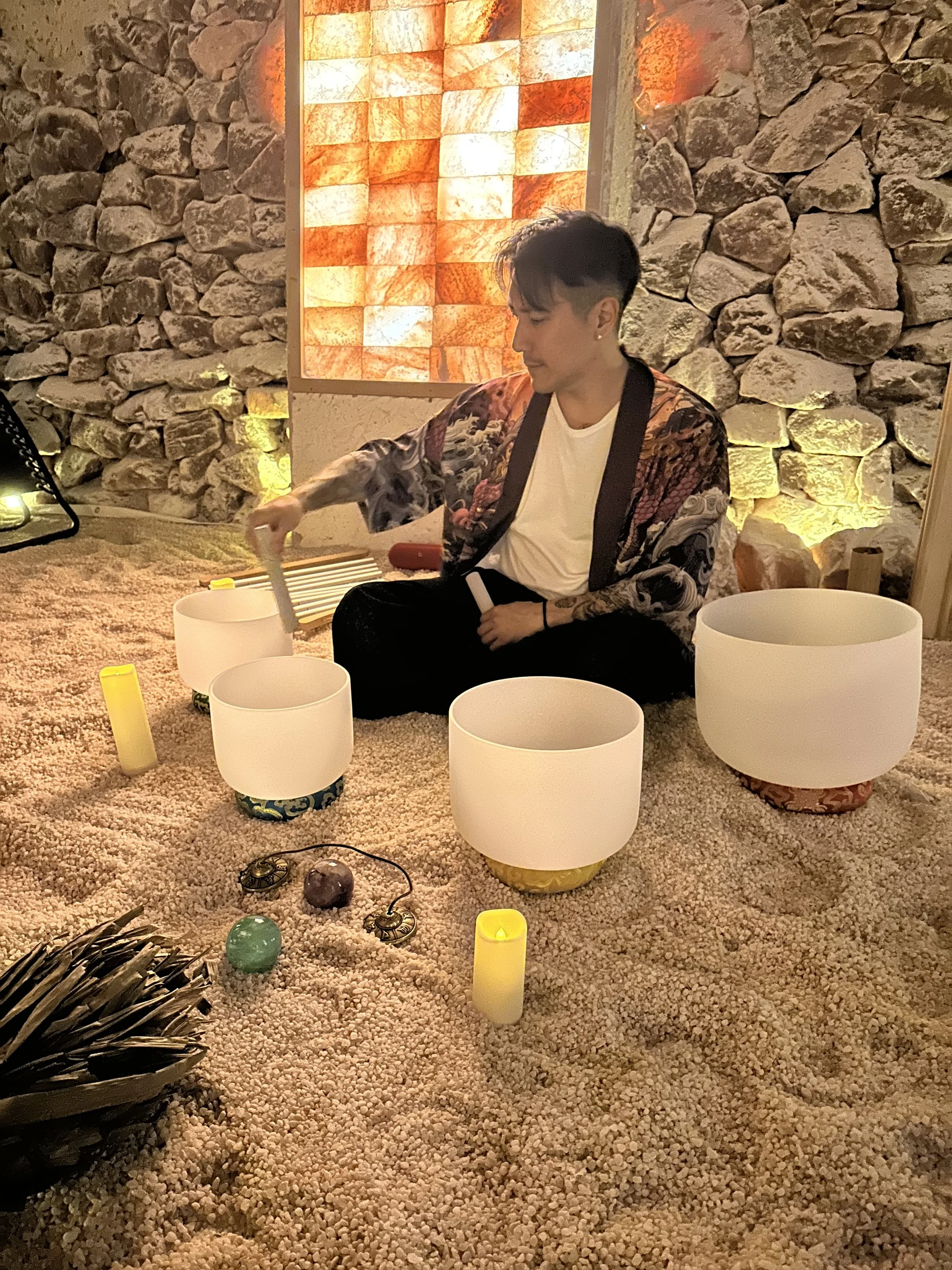 Alex Ma from Solar Soul Circle playing the crystal singing bowls during a sound bath at the Saltwonder Himalayan Salt Cave in North Vancouver