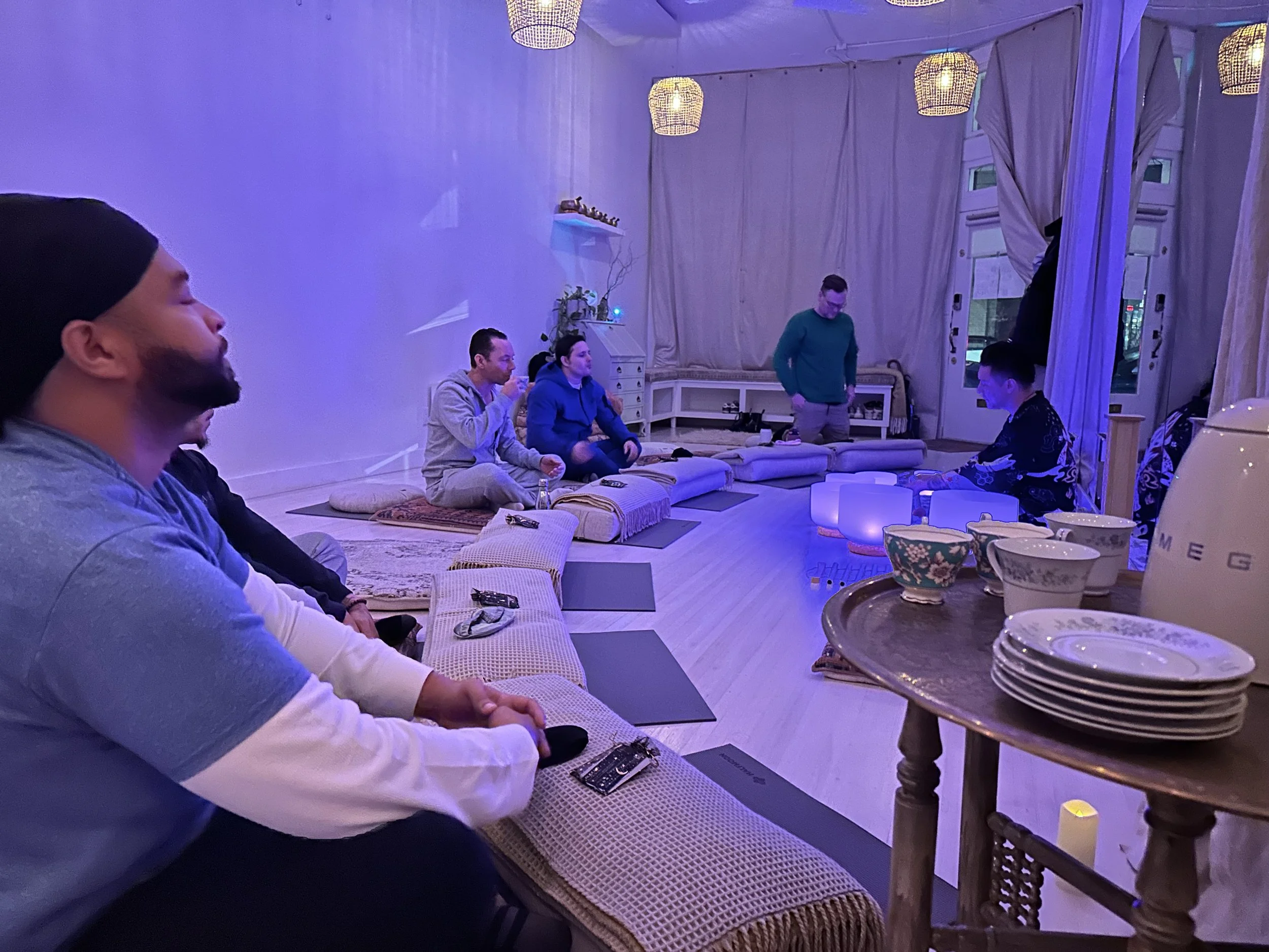 A group of men relaxing after a sound bath in Vancouver sharing their experiences while sipping on tea