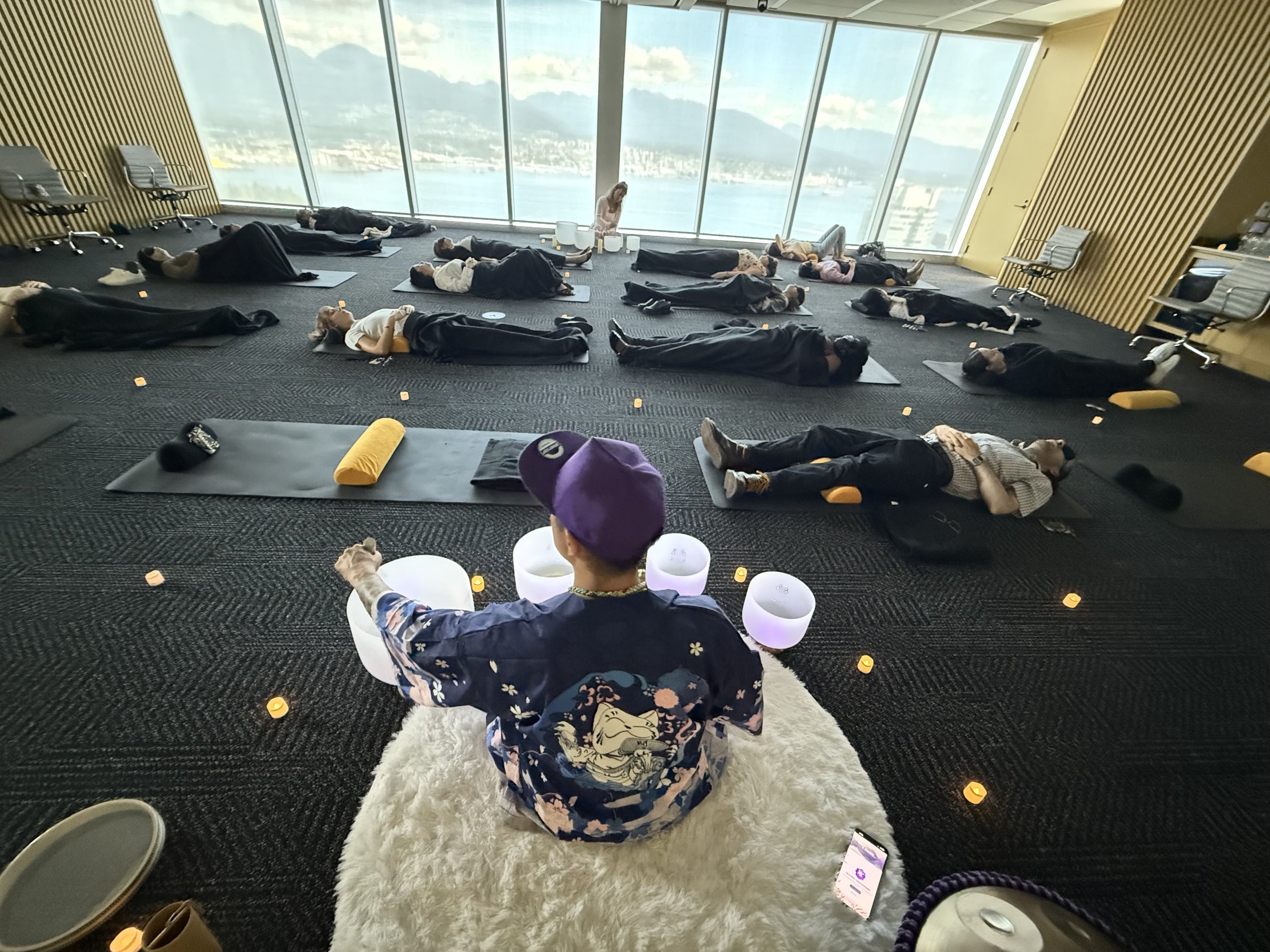 Corporate sound bath wellness event at Blakes Law Firm Vancouver featuring crystal singing bowls, ambient lighting, and employees participating in a workplace wellness experience.