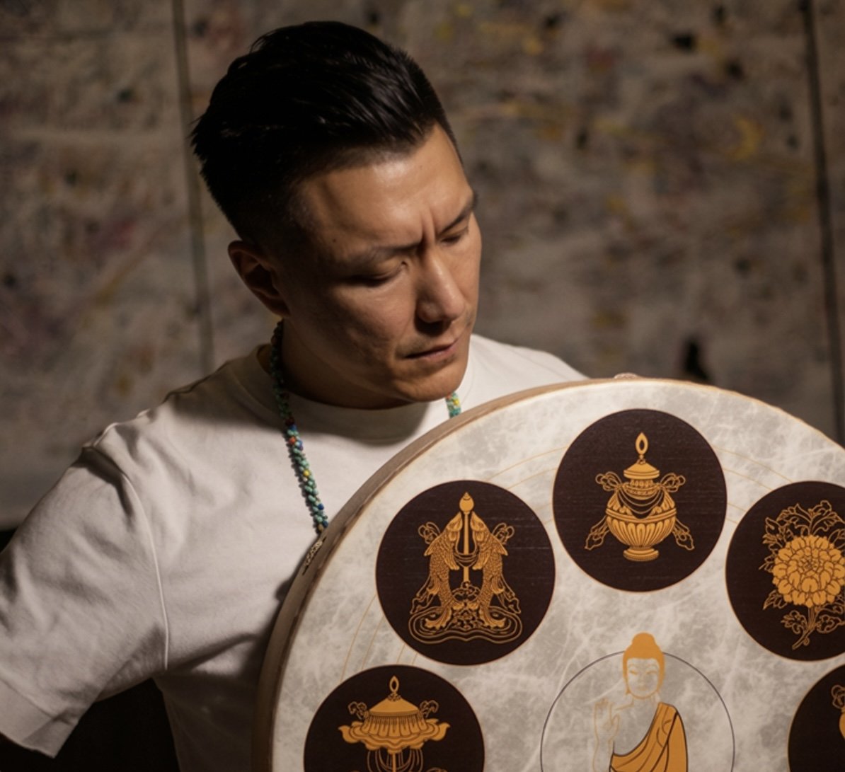 Vancouver sound bath facilitator Alex Ma of Solar Soul Circle holding a buffalo drum for a birthday sound bath.