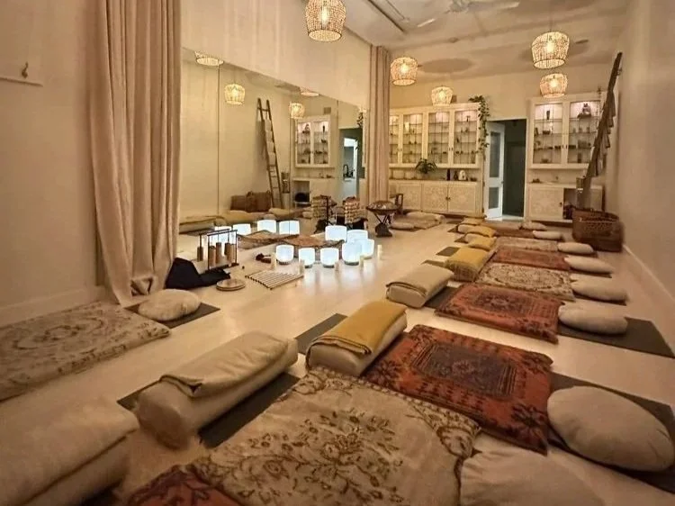 Sound bath relaxation space in Vancouver with yoga mats, blankets, pillows, glowing crystal singing bowls, and candles