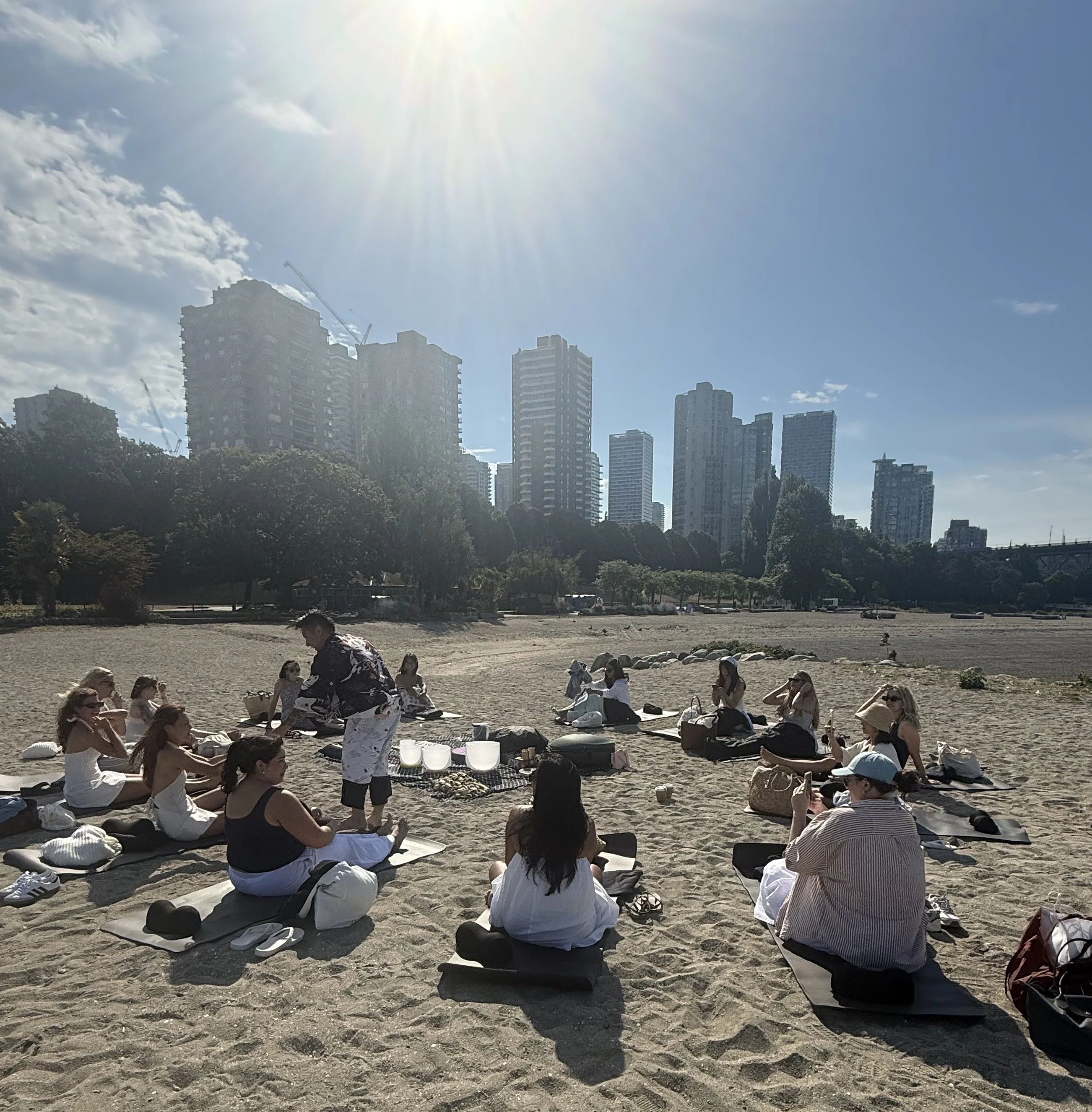 Alex Ma handing out eyemasks to sound bath guests at the beach