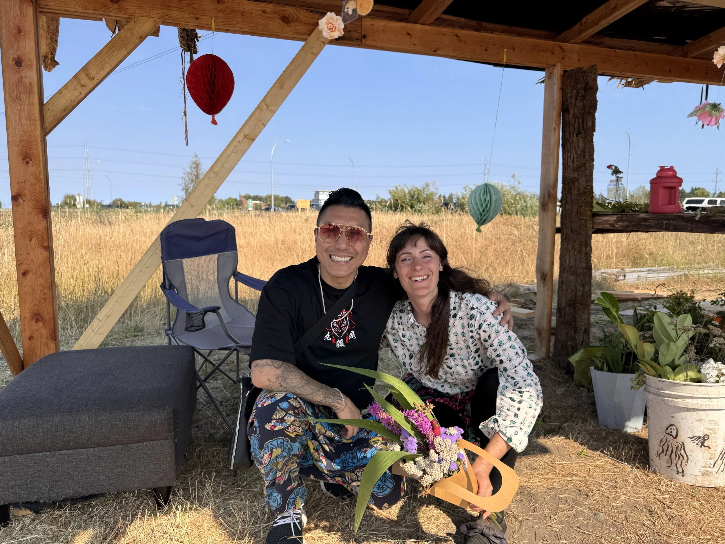 Alex smiling with Jessica from Petal Paradise receiving a bouquet as a gift
