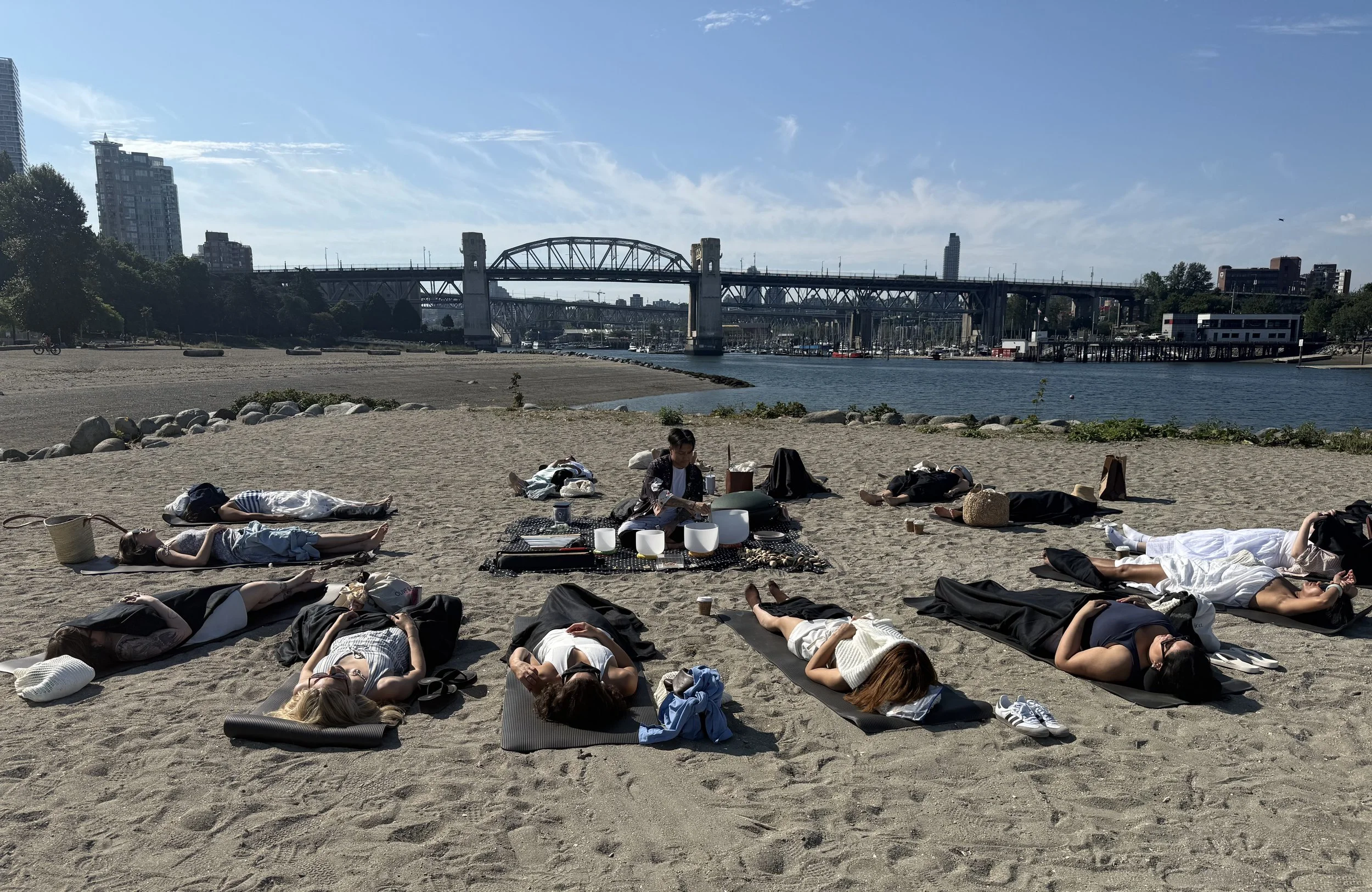 Alex Ma playing the crystal sound bowls in Vancouver at Third Beach for a corporate wellness sound bath