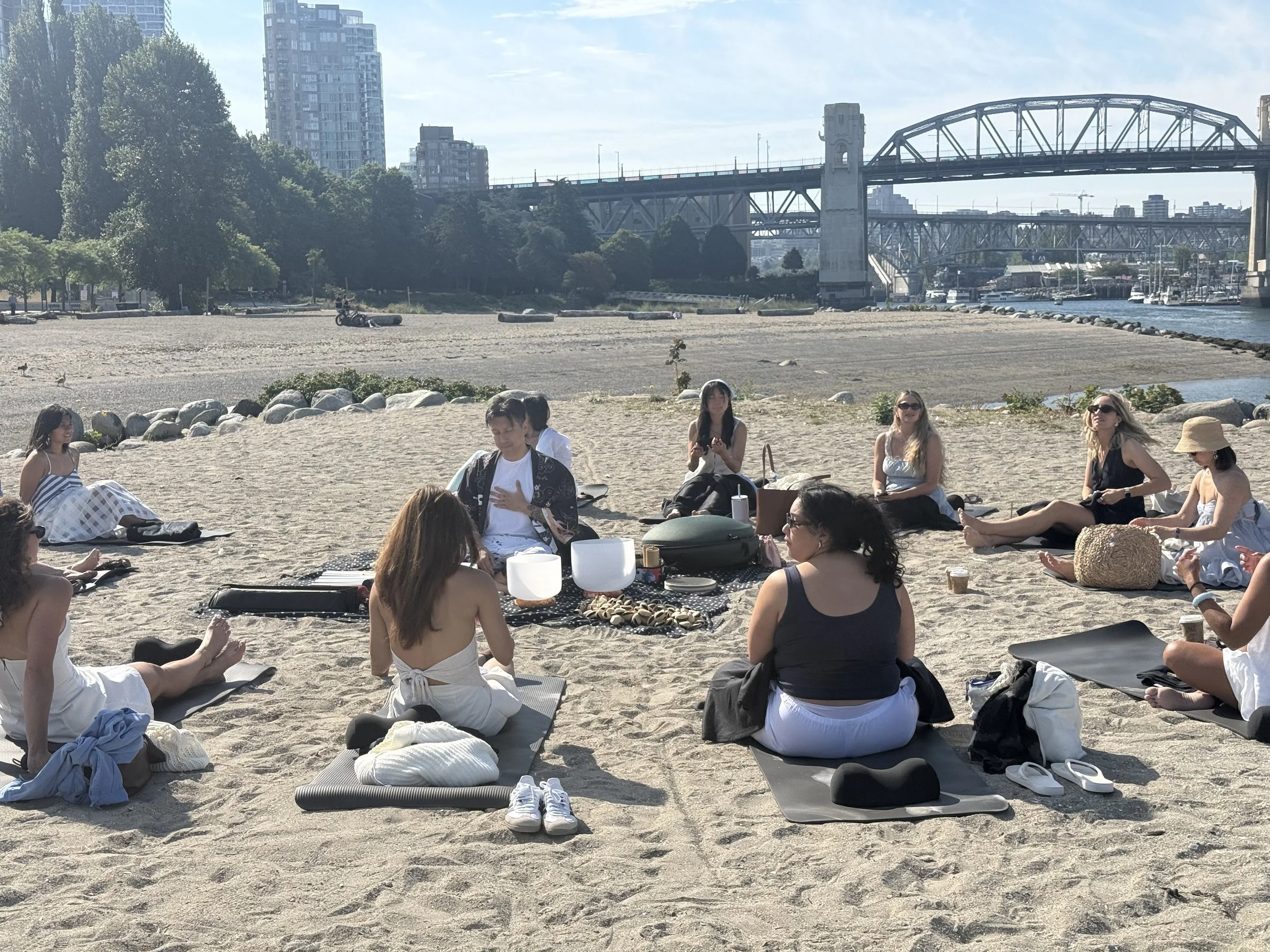 Alex Ma with his hand over his heart holding space for the sound healing guests for a beach themed corporate sound bath