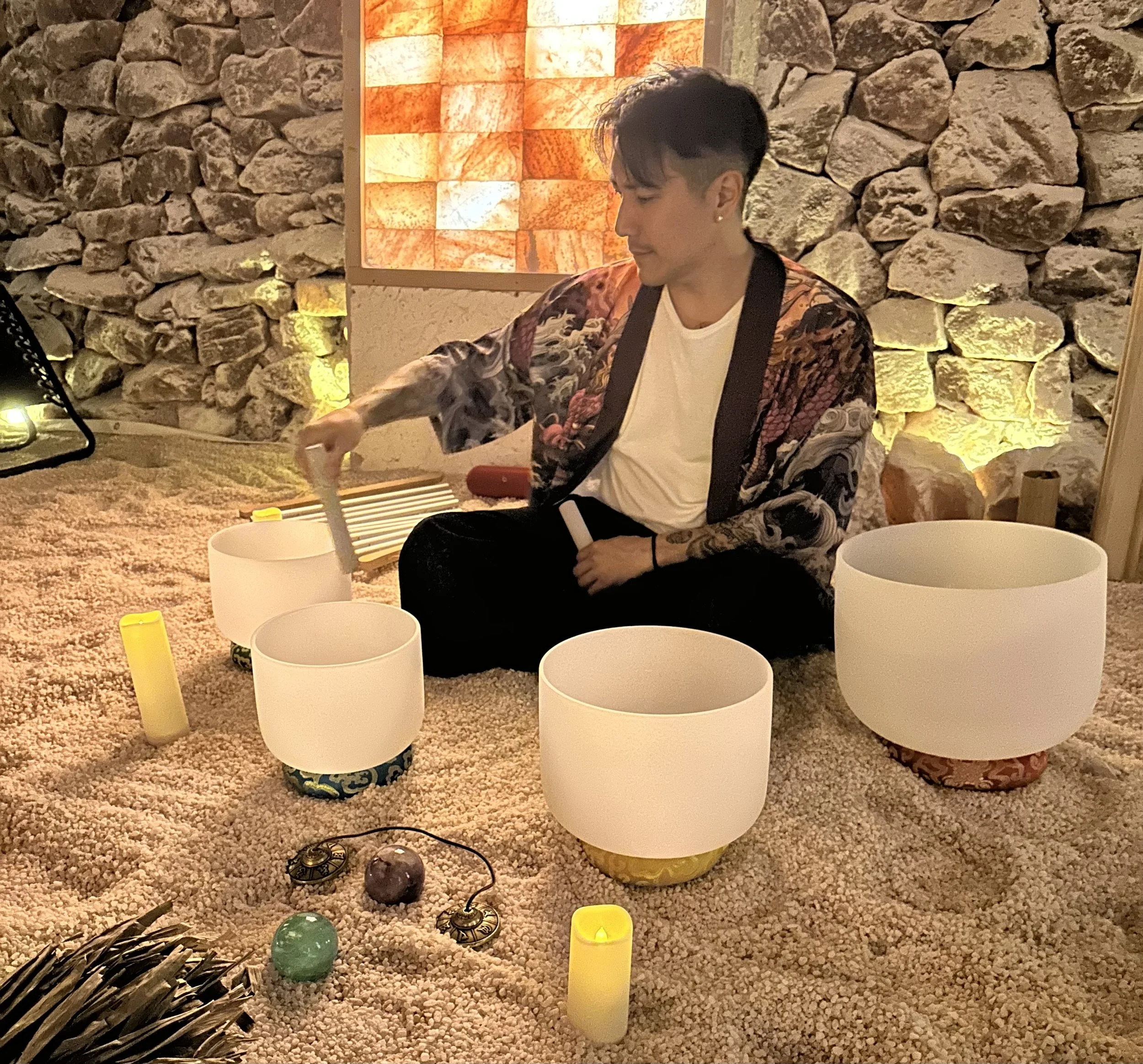 Alex Ma of Solar Soul Circle facilitating a group sound bath in Vancouver with crystal singing bowls, handpan, chimes, and calming instruments.