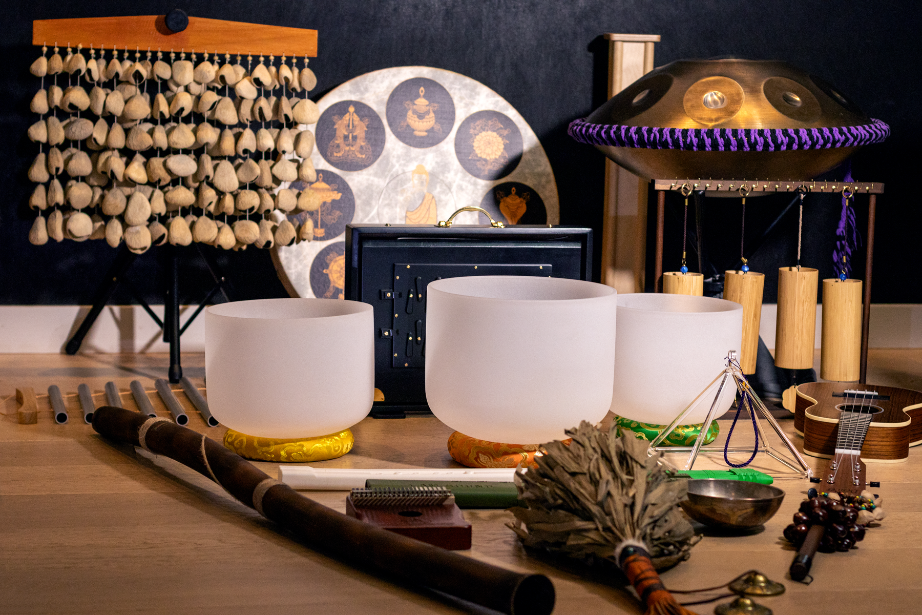 Sound healing instruments for a birthday sound bath in Vancouver, including crystal singing bowls, handpan, chimes, drum, crystal pyramid, rain stick, and calming sound tools.