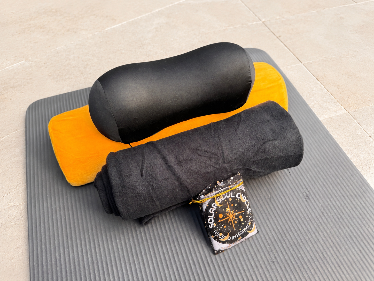 A sound bath yoga mat setup including pillow, yoga mat, bolster, blanket and gift bag provided by Solar Soul Circle.