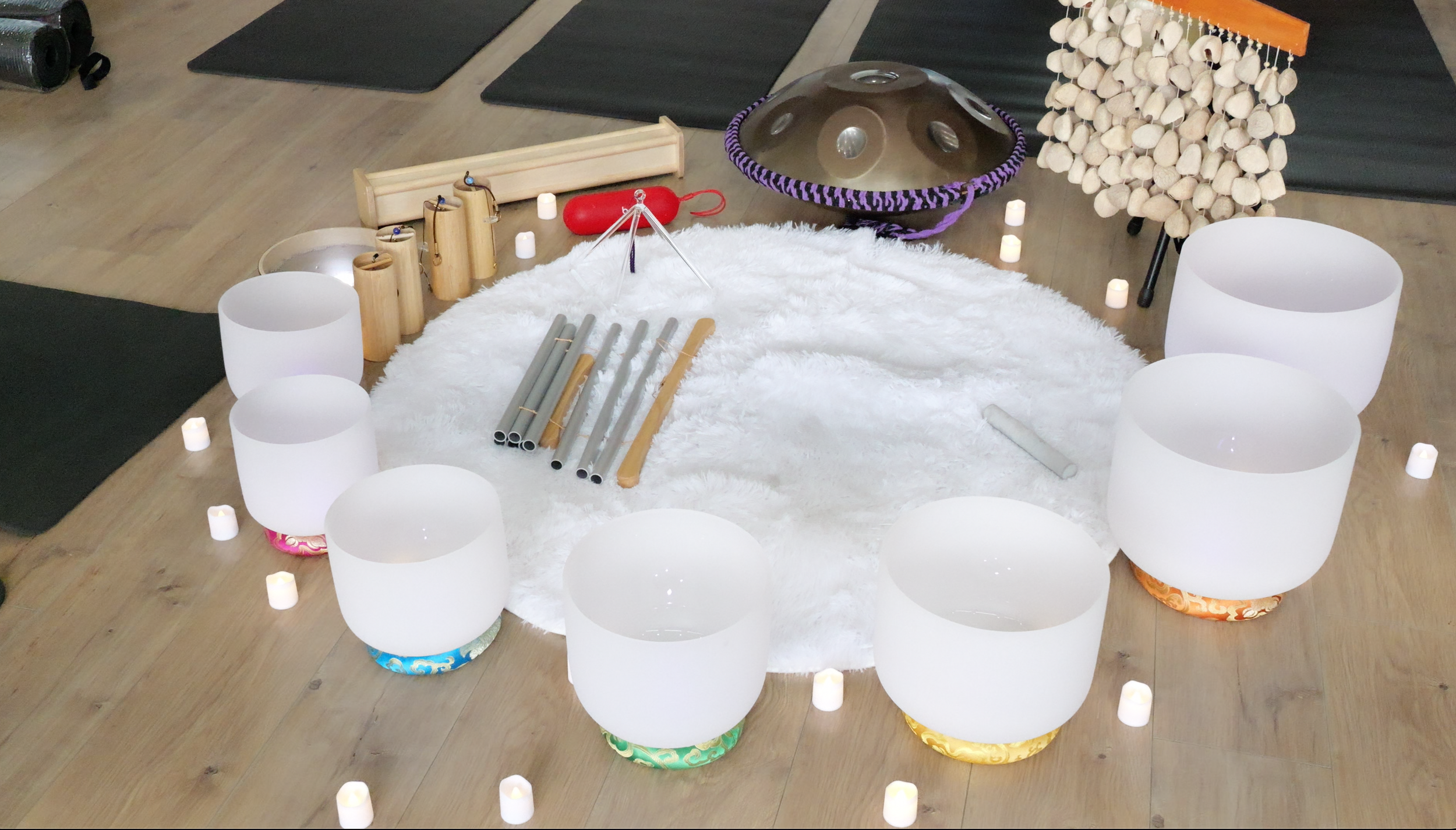 Crystal singing bowls and other healing instruments for sound therapy laid out at a sound bath in Surrey