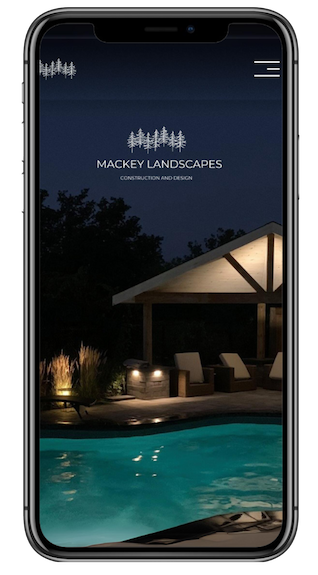 Mobile phone displaying the homepage of Mackey Landscapes, featuring an outdoor pool area at night with lighting, trees, and a pavilion.
