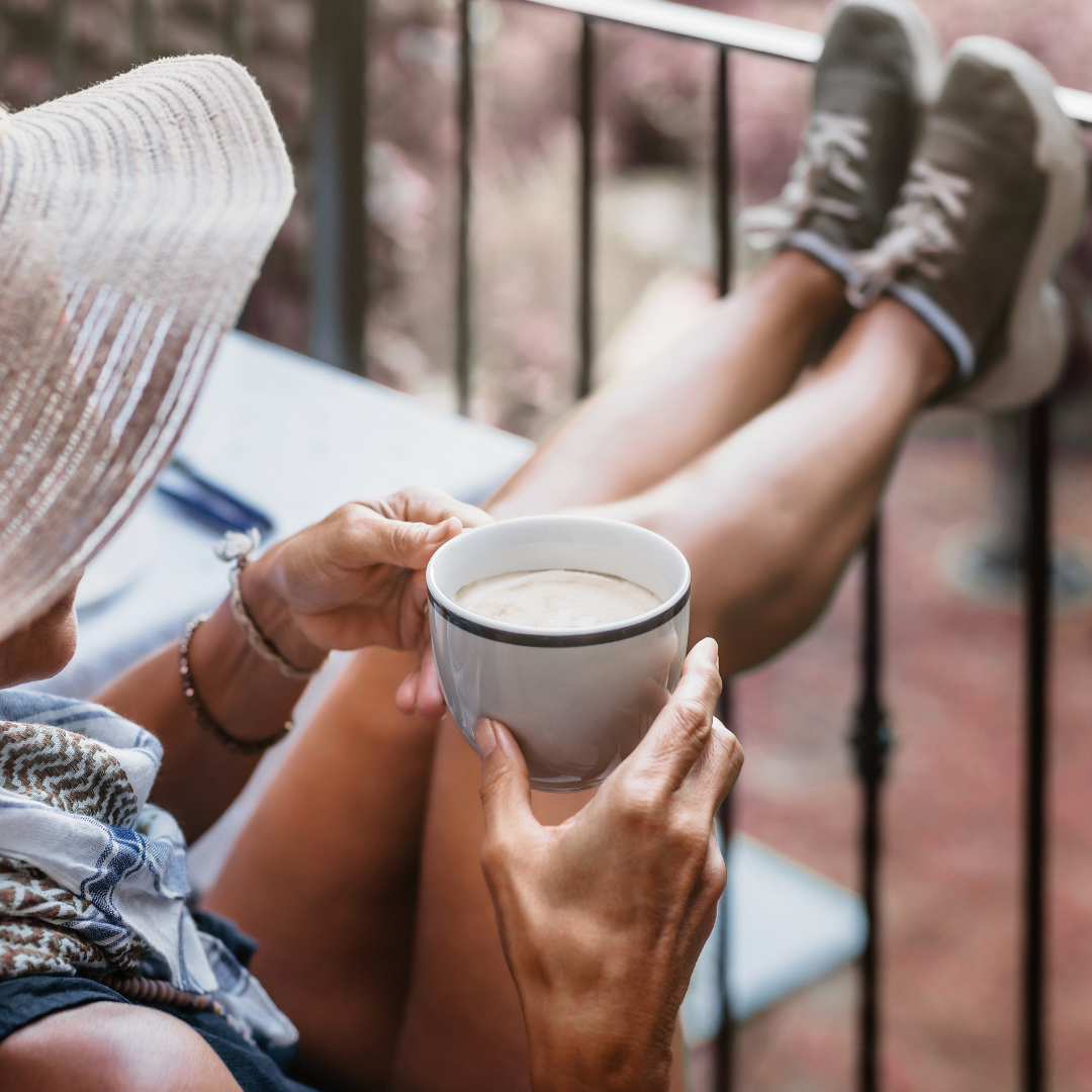 Traveler relaxing with a hot beverage and her feet up because Auntie has handled all the planning for her trip!