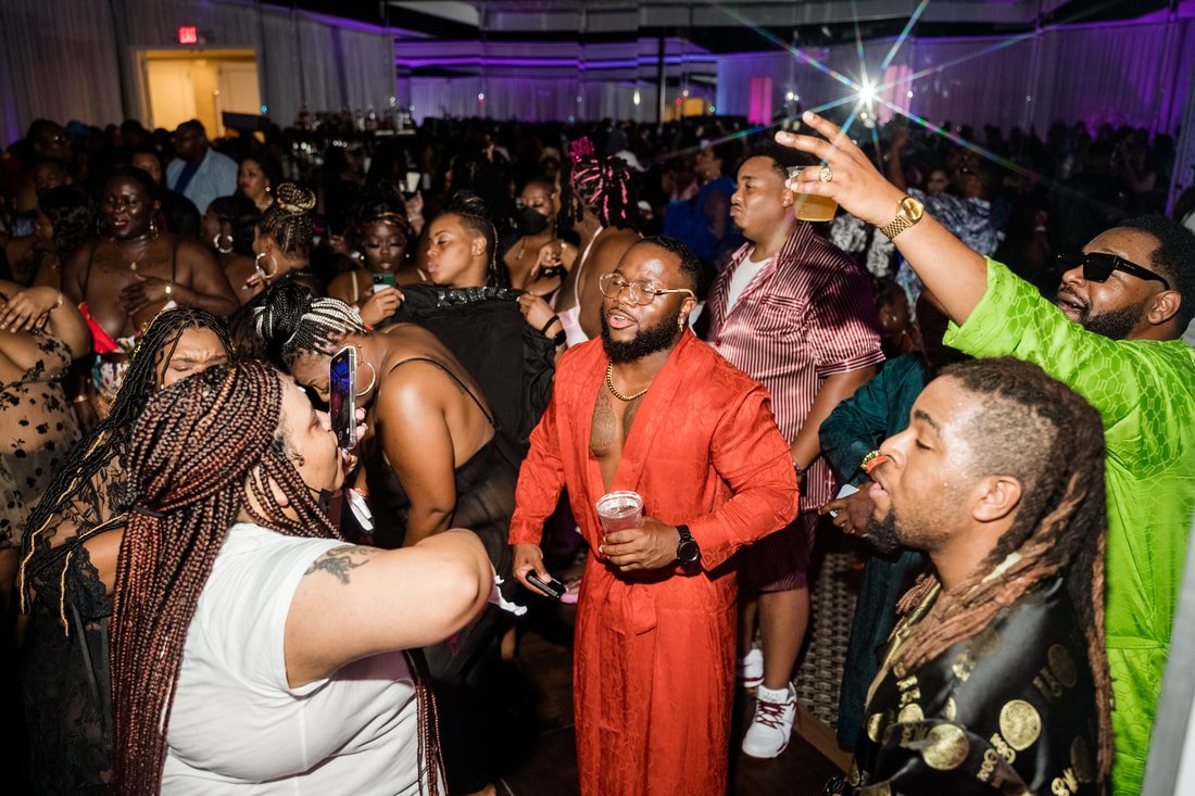 People partying at a nightclub or party with colorful lighting.