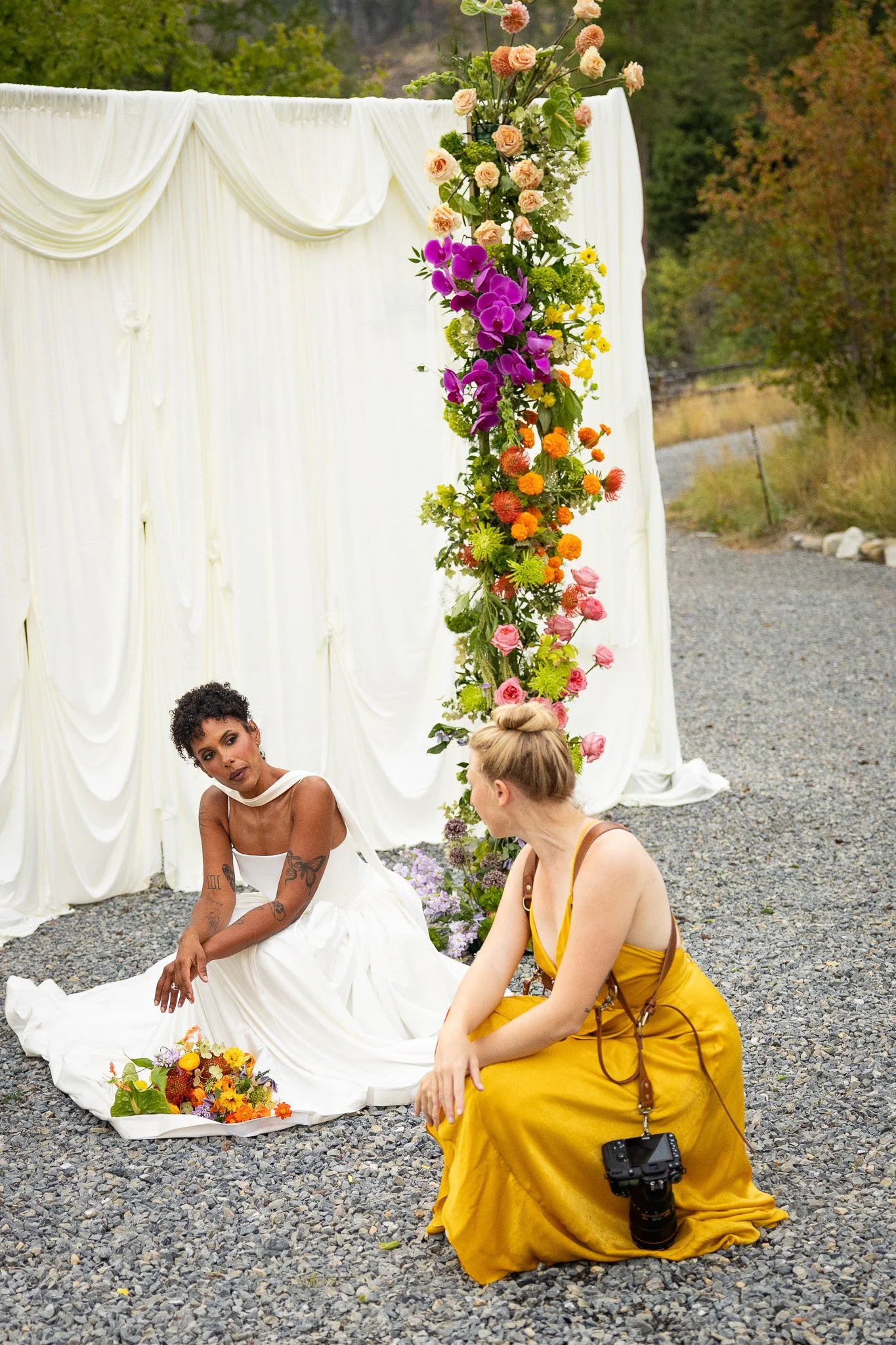 woman in yellow dress and cameras guiding bride how to pose