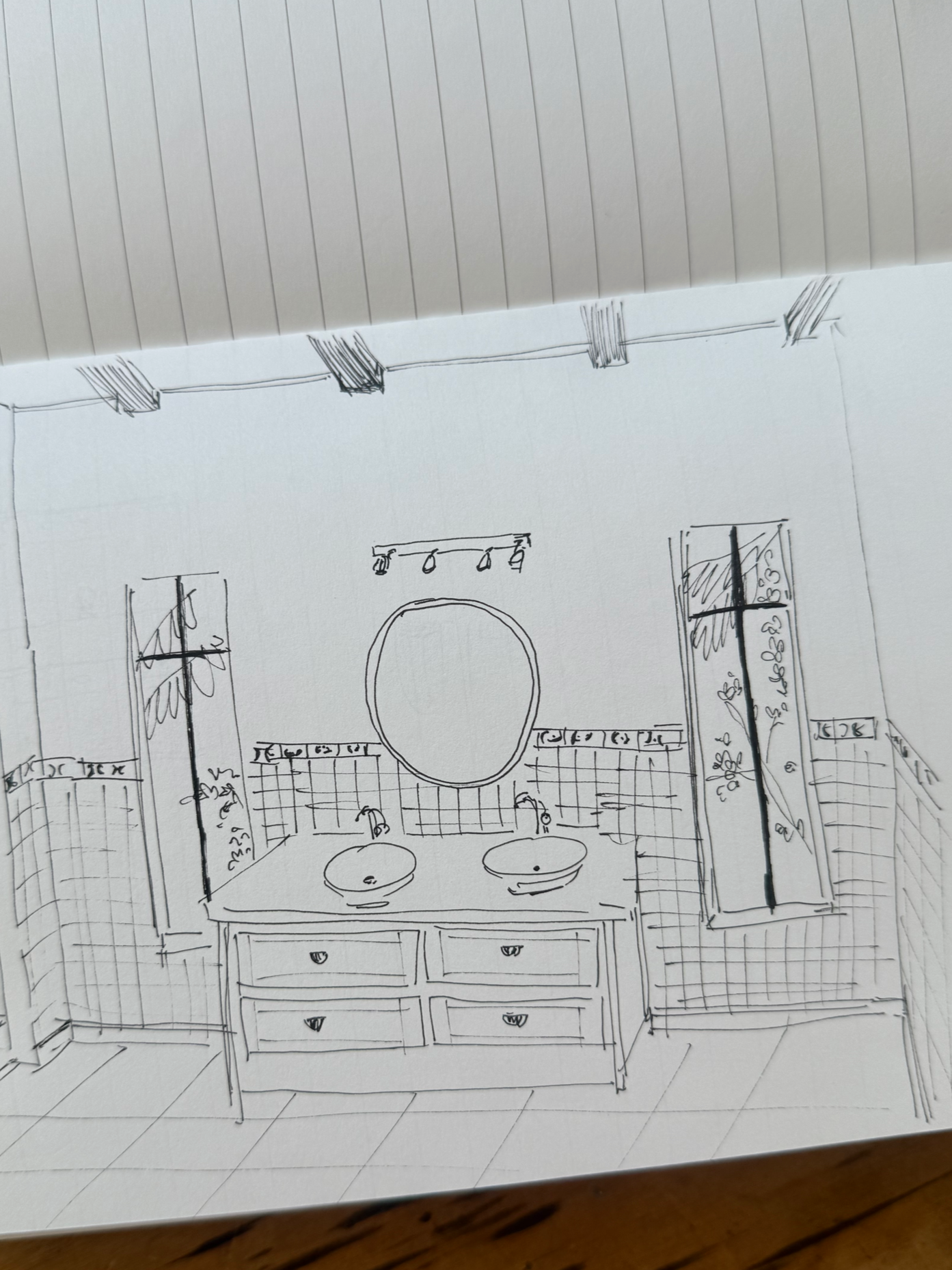 Sketch of a bathroom vanity with two sinks, a circular mirror, wall-mounted shelves, and windows with plants.
