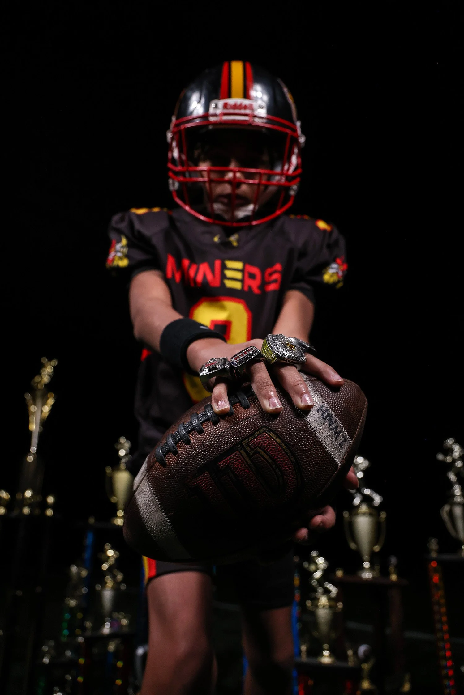 Midwest Miner Football player with ball and championship rings