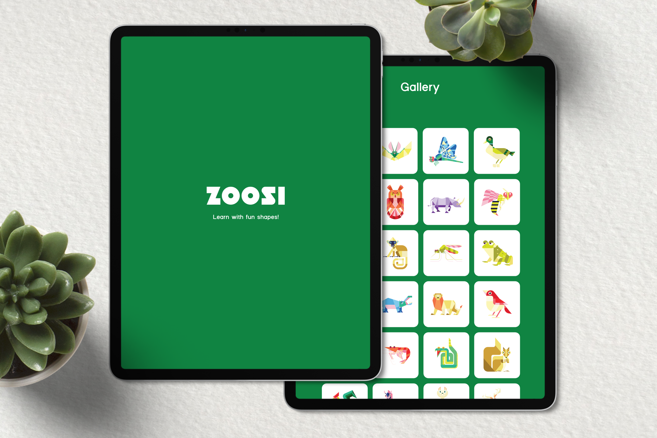 Two digital tablets on a table displaying a children's educational app called 'ZOOSI' with the tagline 'Learn with fun shapes!' One tablet shows the app's opening screen, and the other displays a gallery of colorful, geometric animal illustrations. There are green succulents near the tablets.
