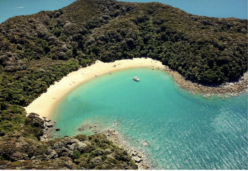 A crescent of golden sand and a boat anchored in turquoise water