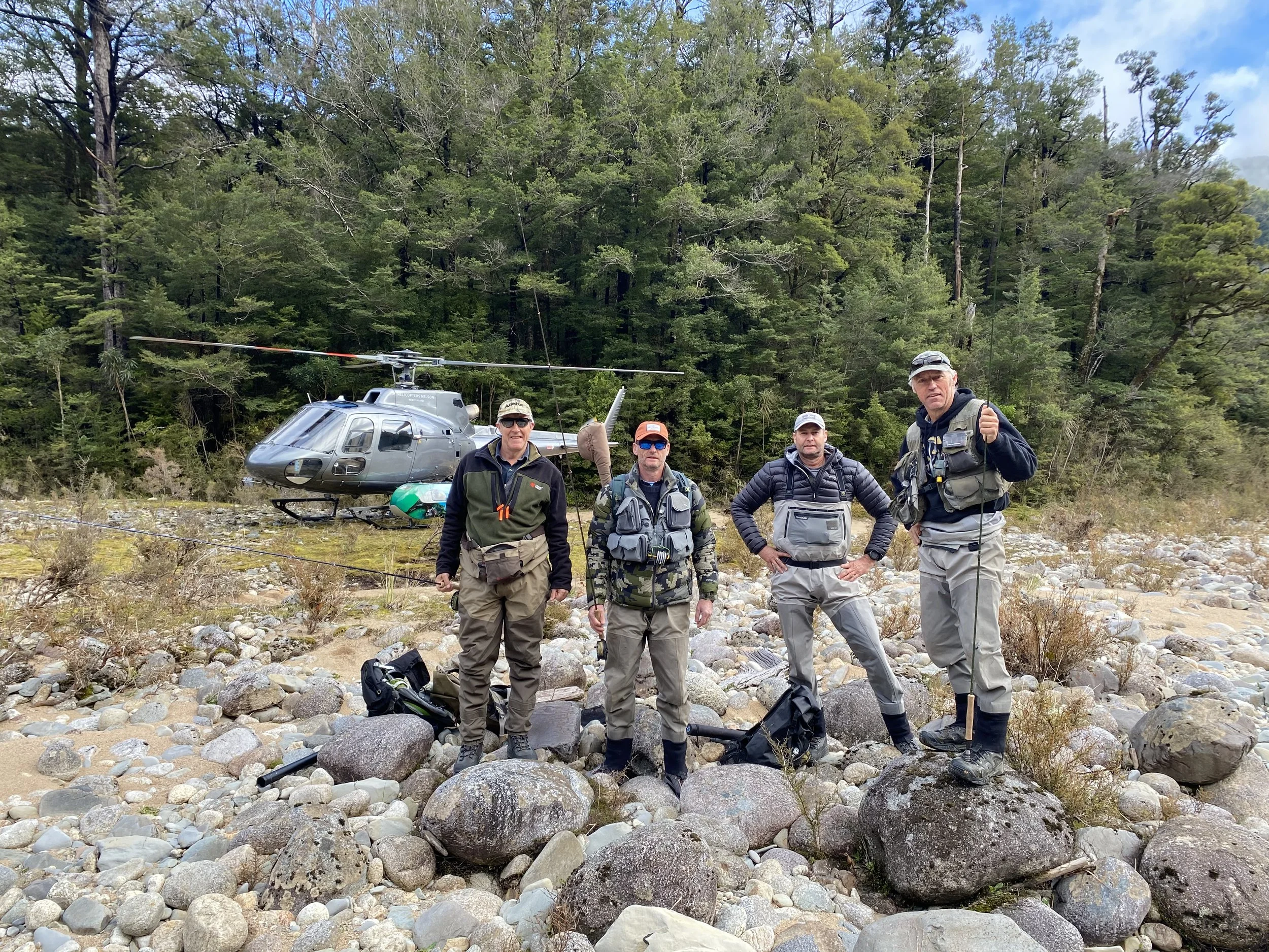 Fishing group celebrating successful catch by helicopter in remote New Zealand
