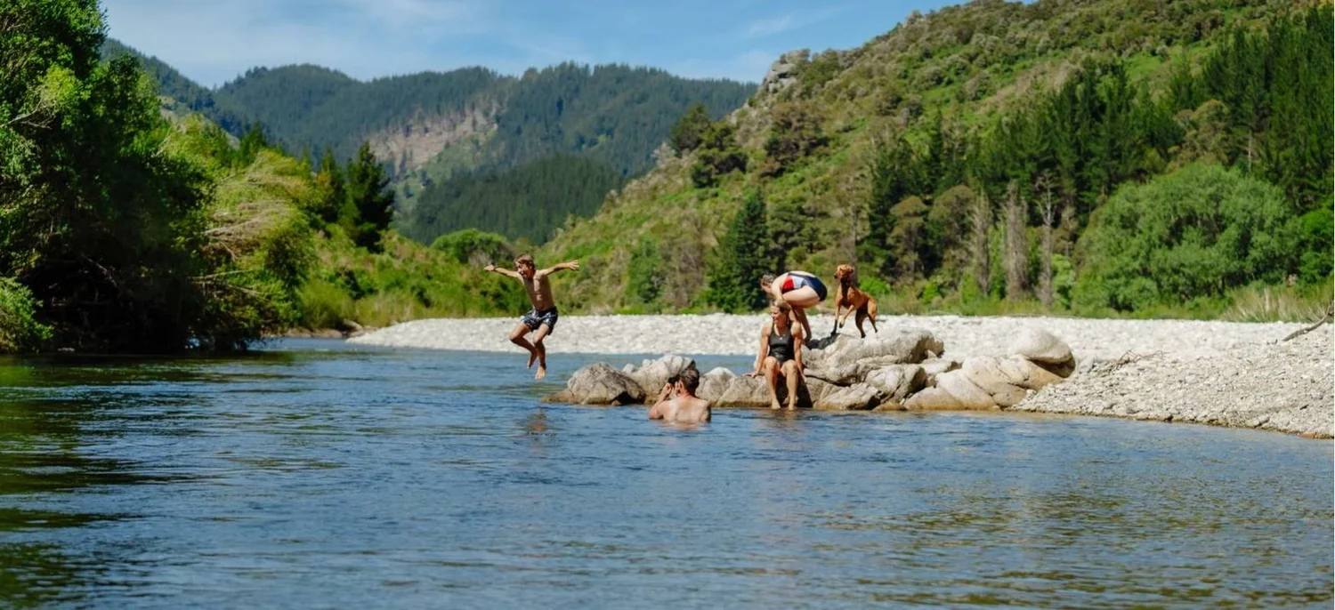 Guests swimming and jumping into the Motueka River below the lodge