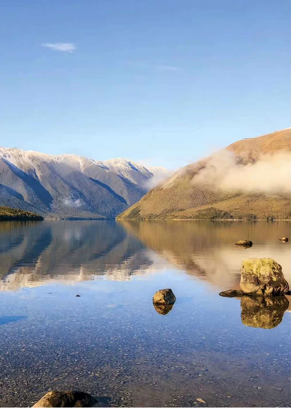 Snow-dusted peaks reflected in a still alpine lake