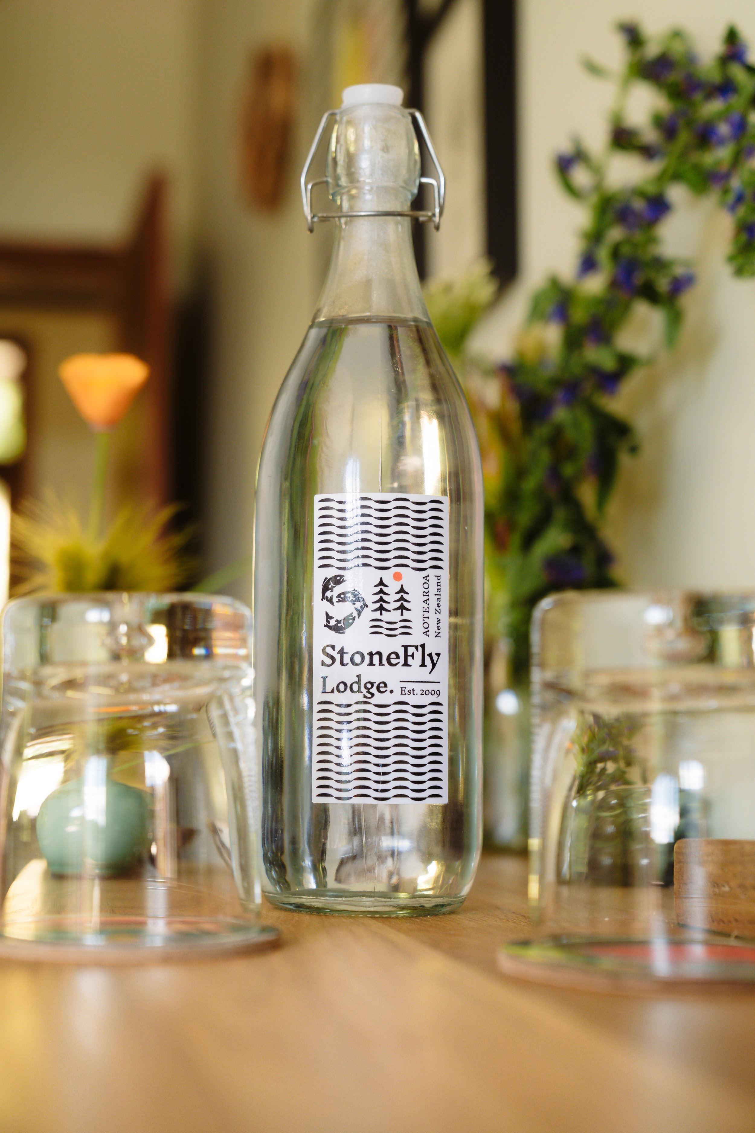 Stonefly Lodge branded glass water bottle on dining table