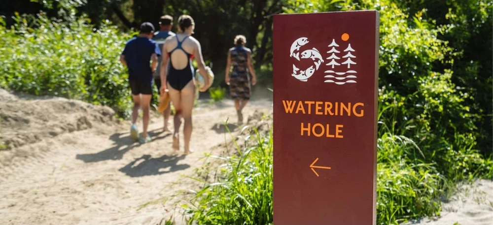 Guests walking the sandy track to the Watering Hole beside the Motueka River