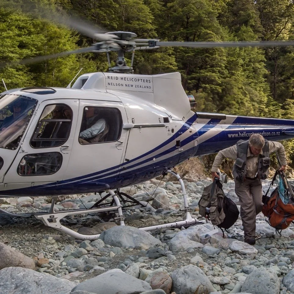 Angler carrying gear about to start Heli-fishing near Stonefly Lodge